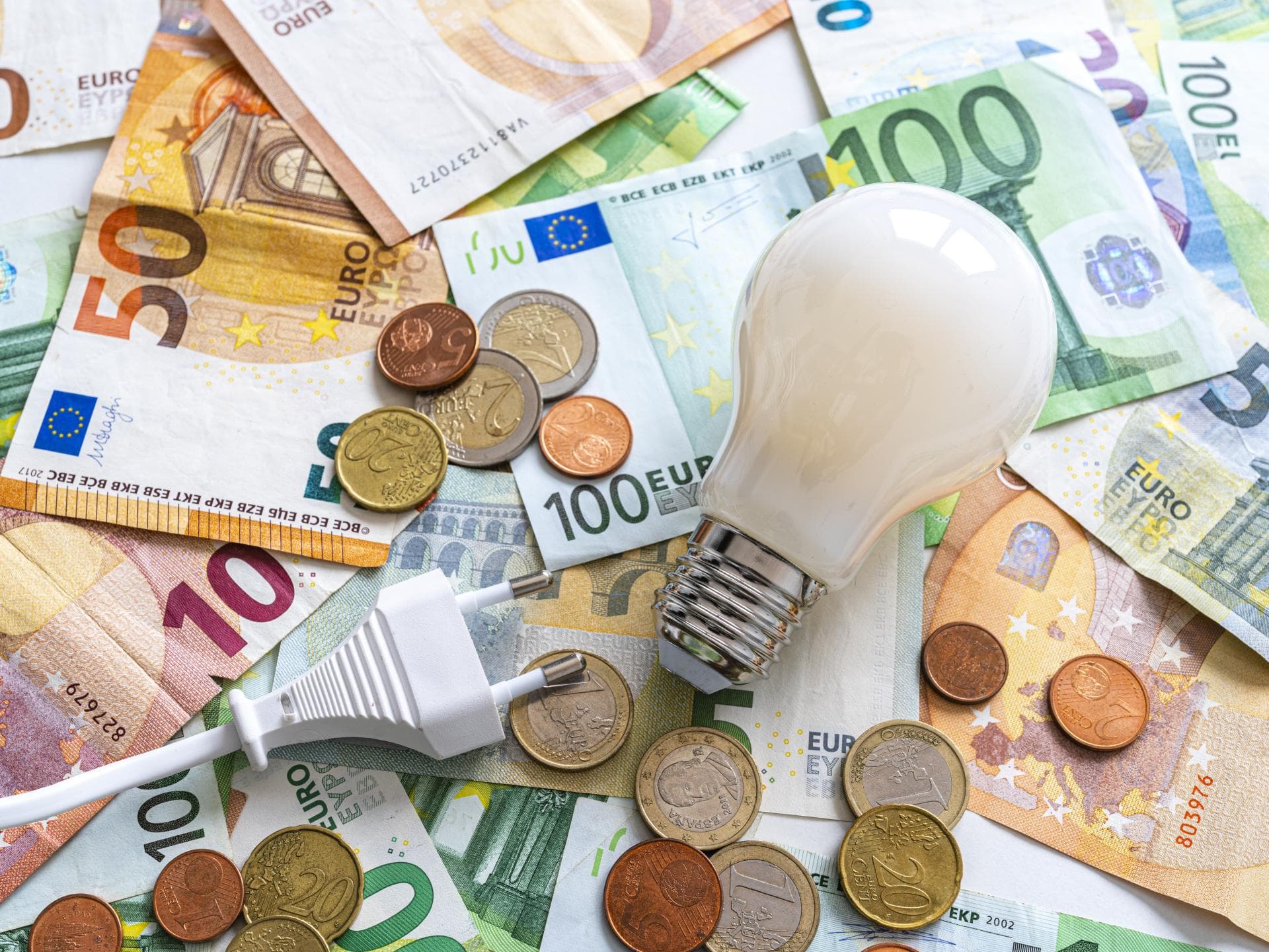 Glühbirne liegt auf Geld 