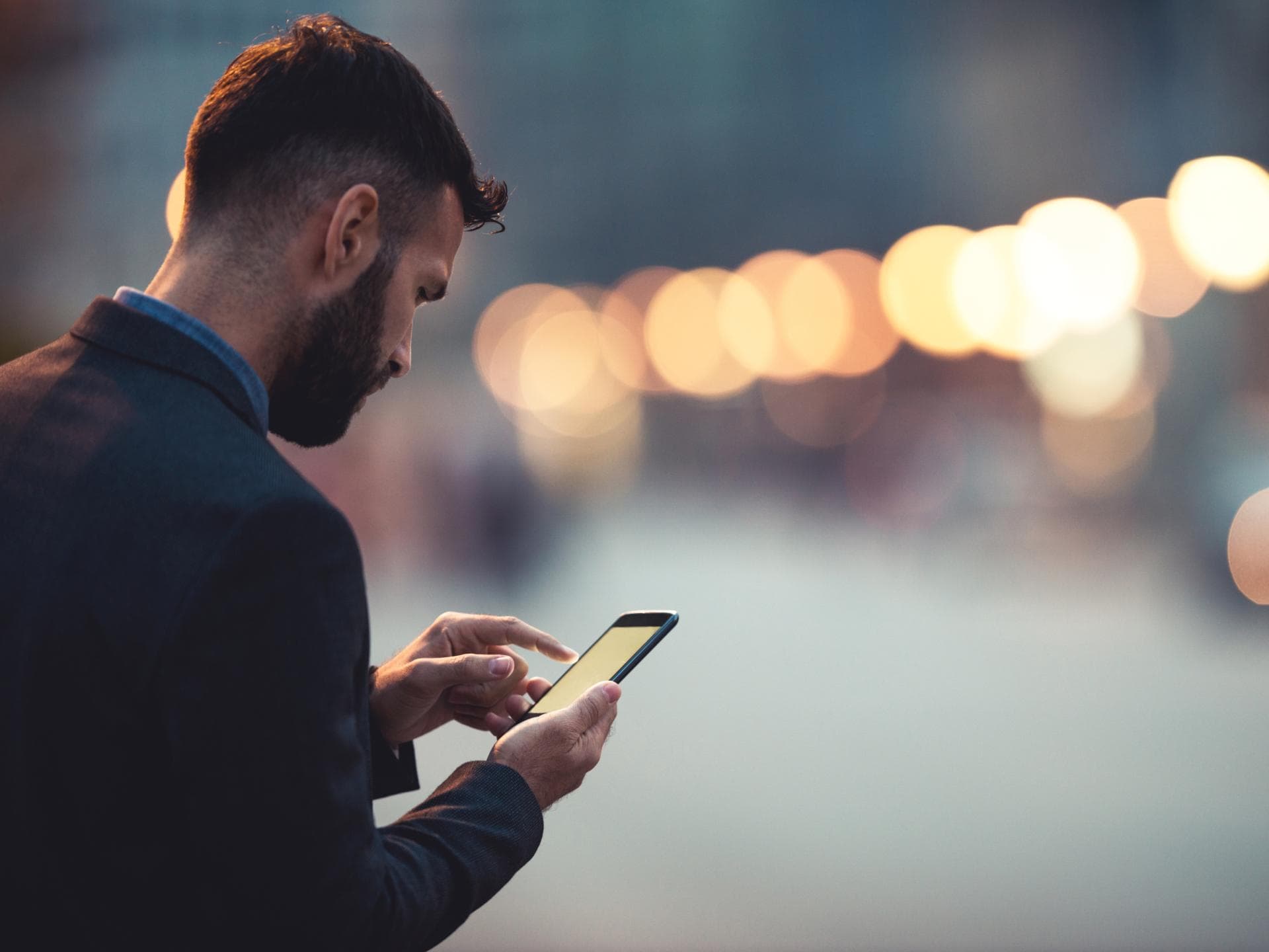 Mann schaut traurig auf Handy