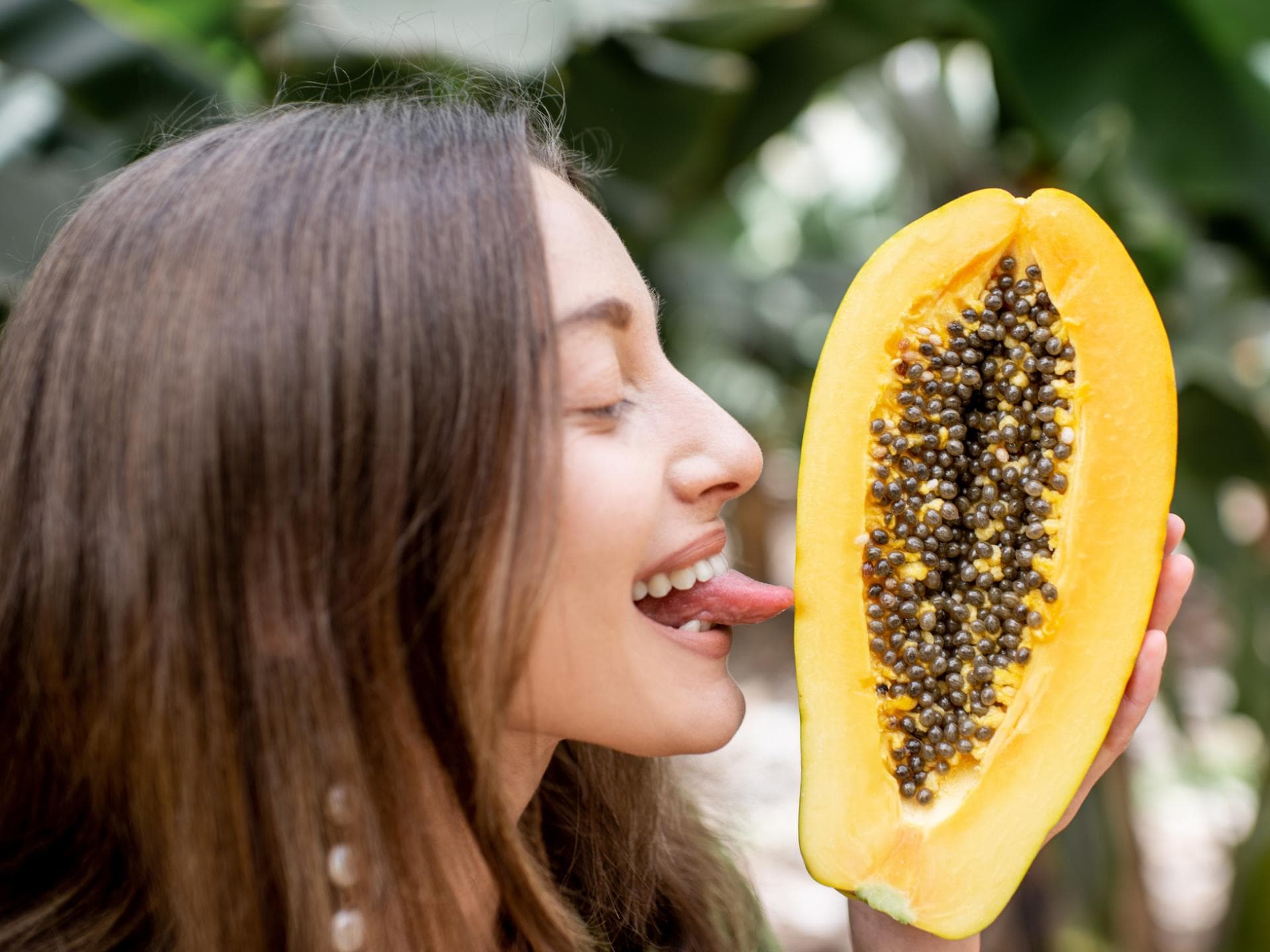 Frau leckt Papaya