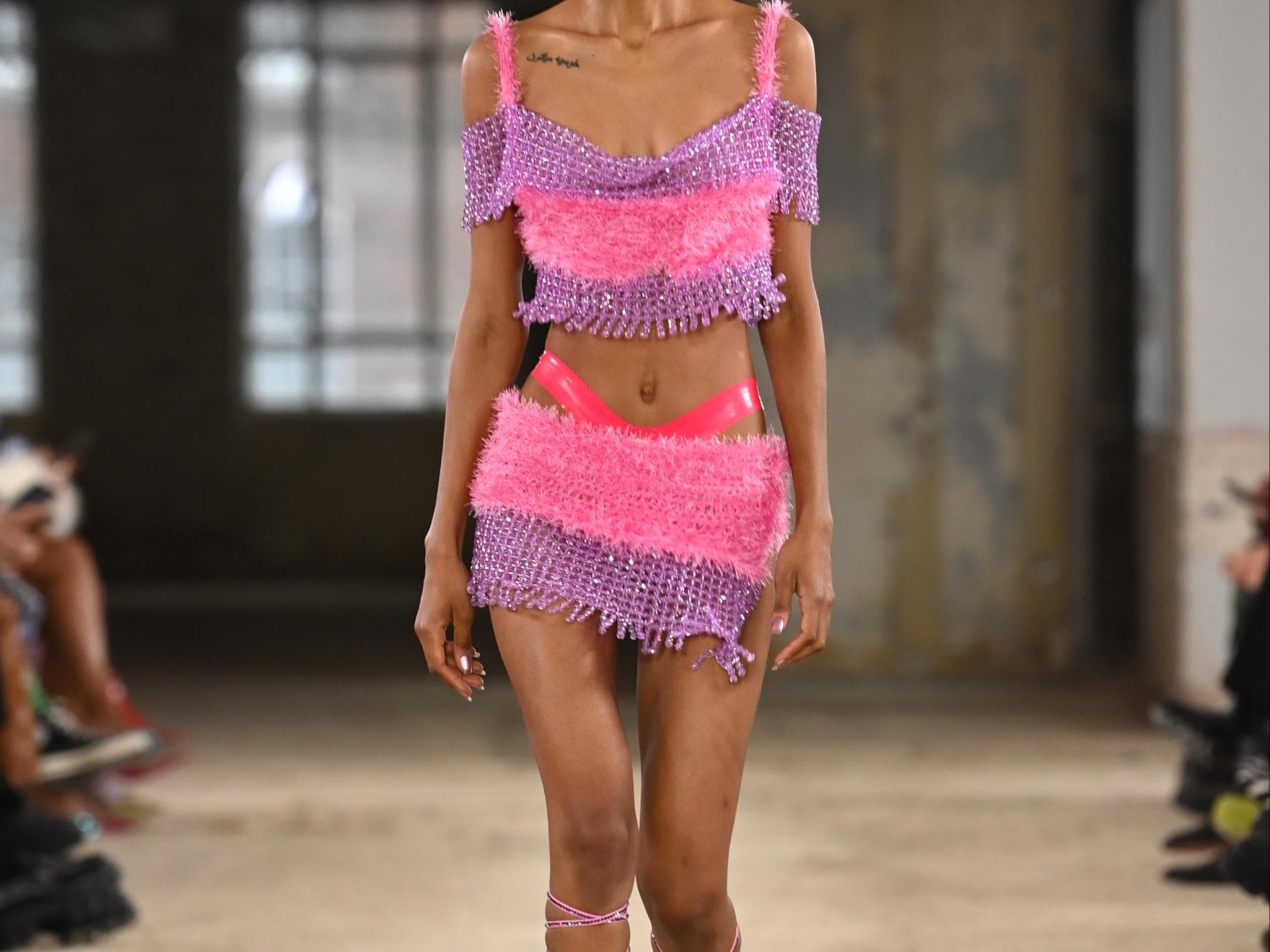 Model auf Laufsteg in pinkem Outfit