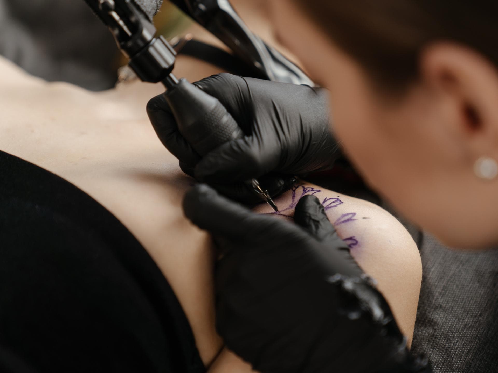 Frau lässt sich Tattoo stechen