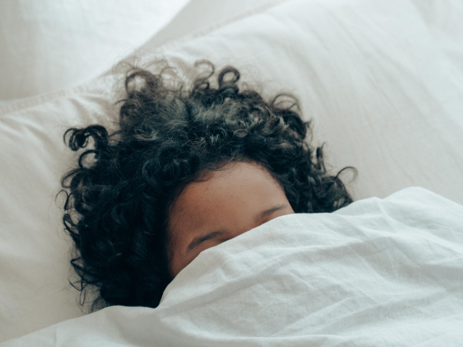 Frau mit Locken im Bett