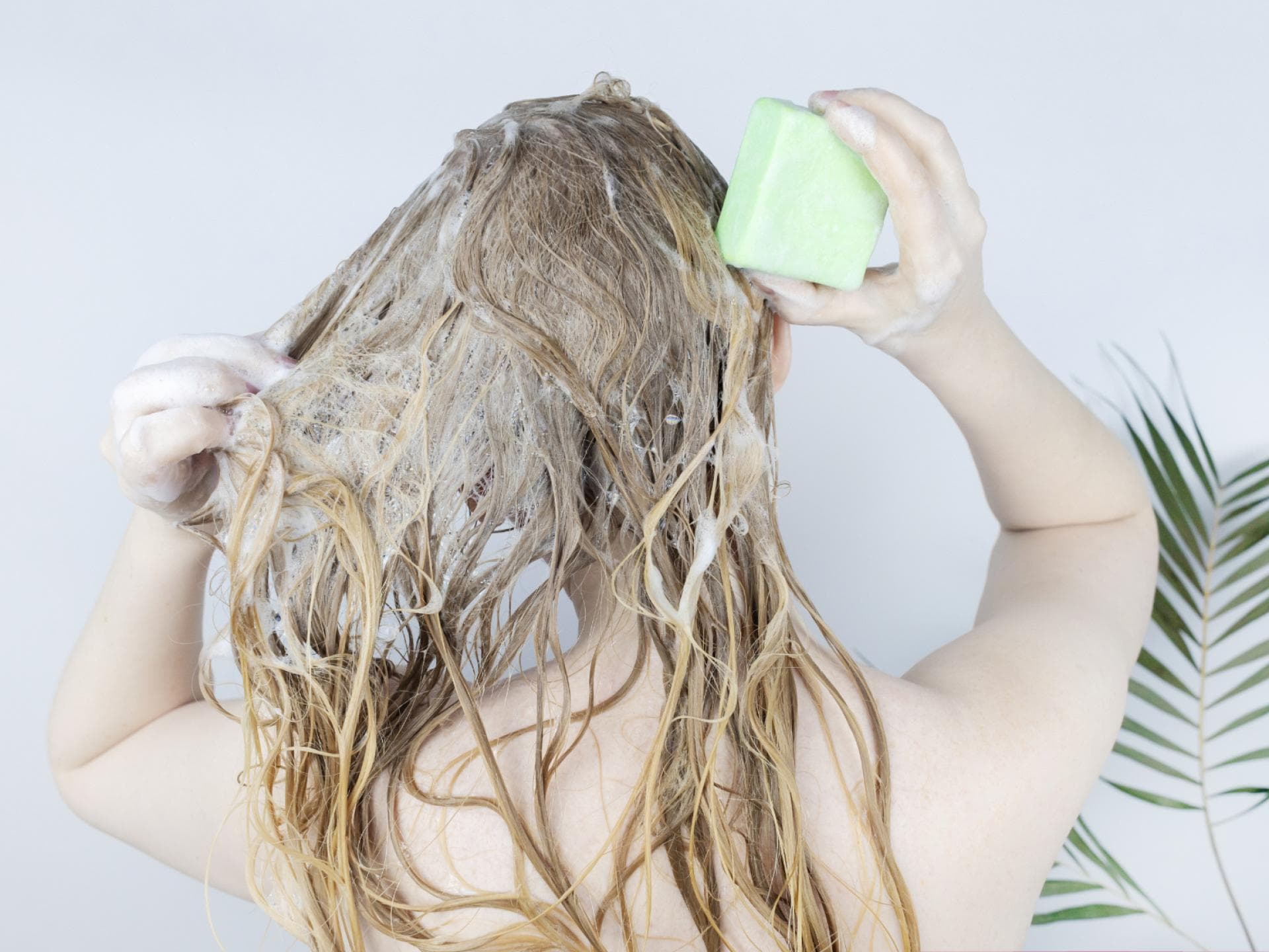 Frau benutzt festes Shampoo
