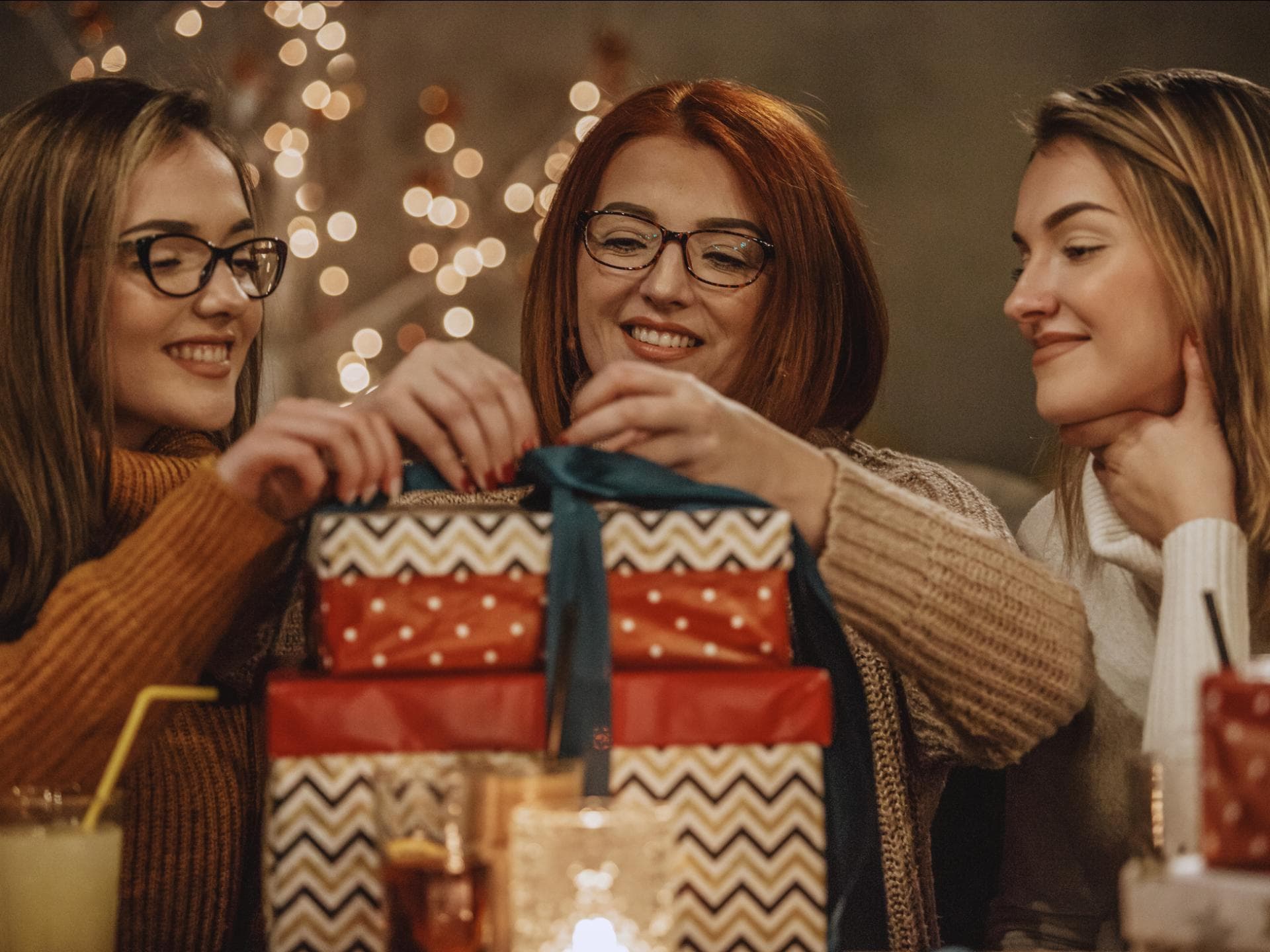 Adventskalender für Mütter zwei junge Frauen mit Mutter und Weihnachtsgeschenken