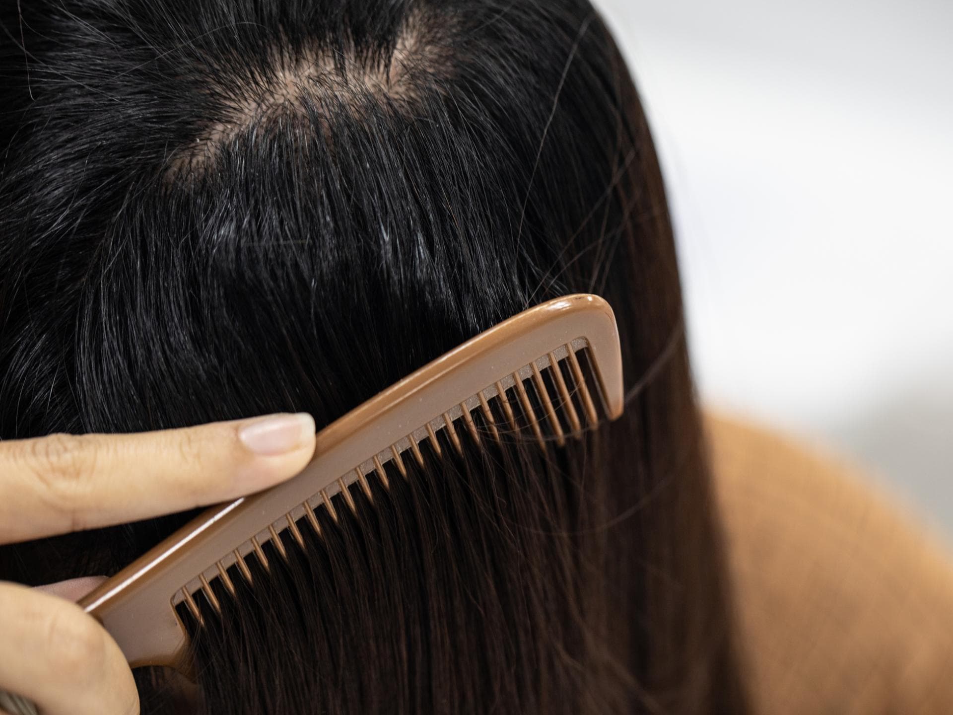 Frau kämmt Haare durch