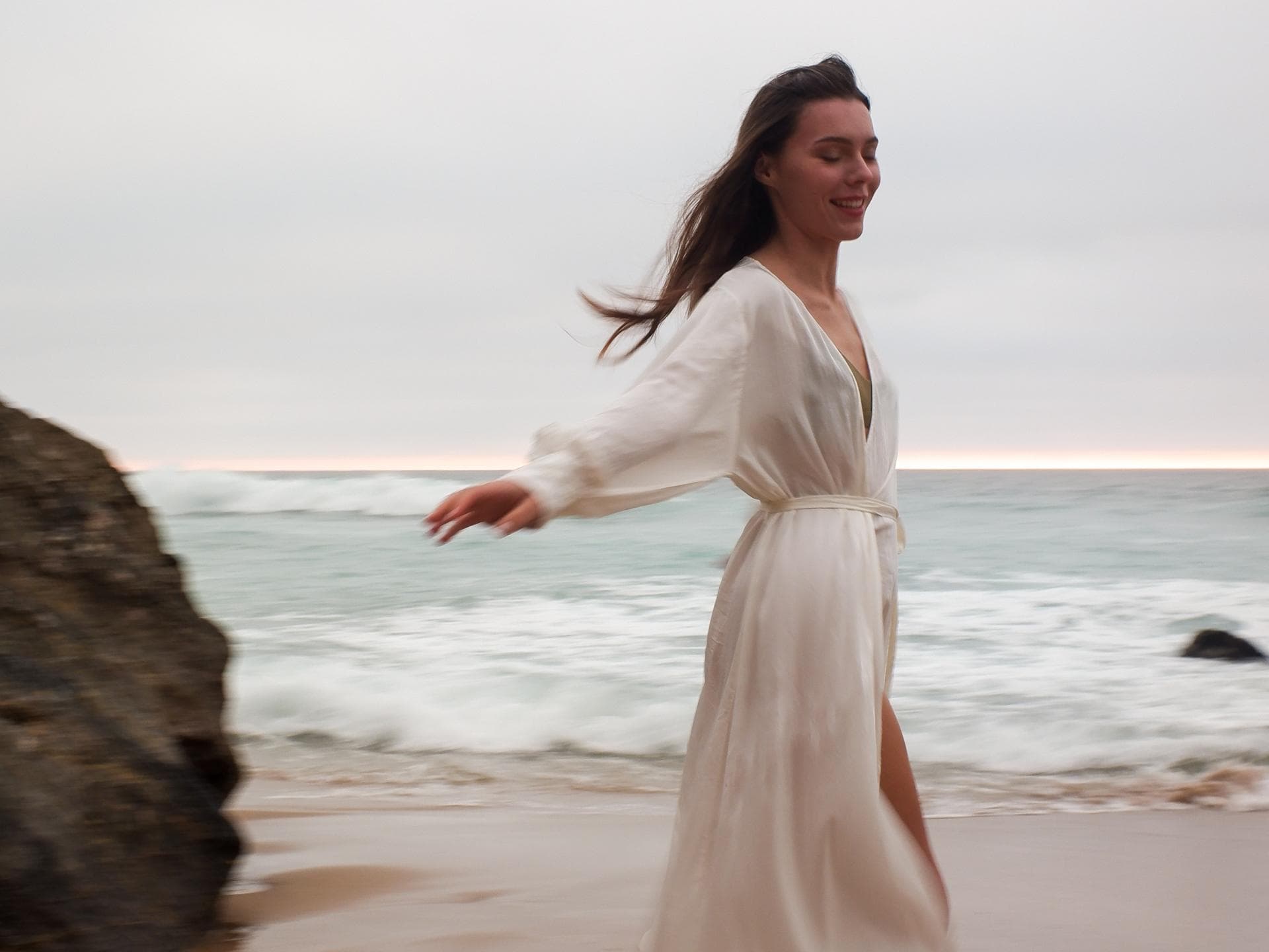 Frau steht am Strand