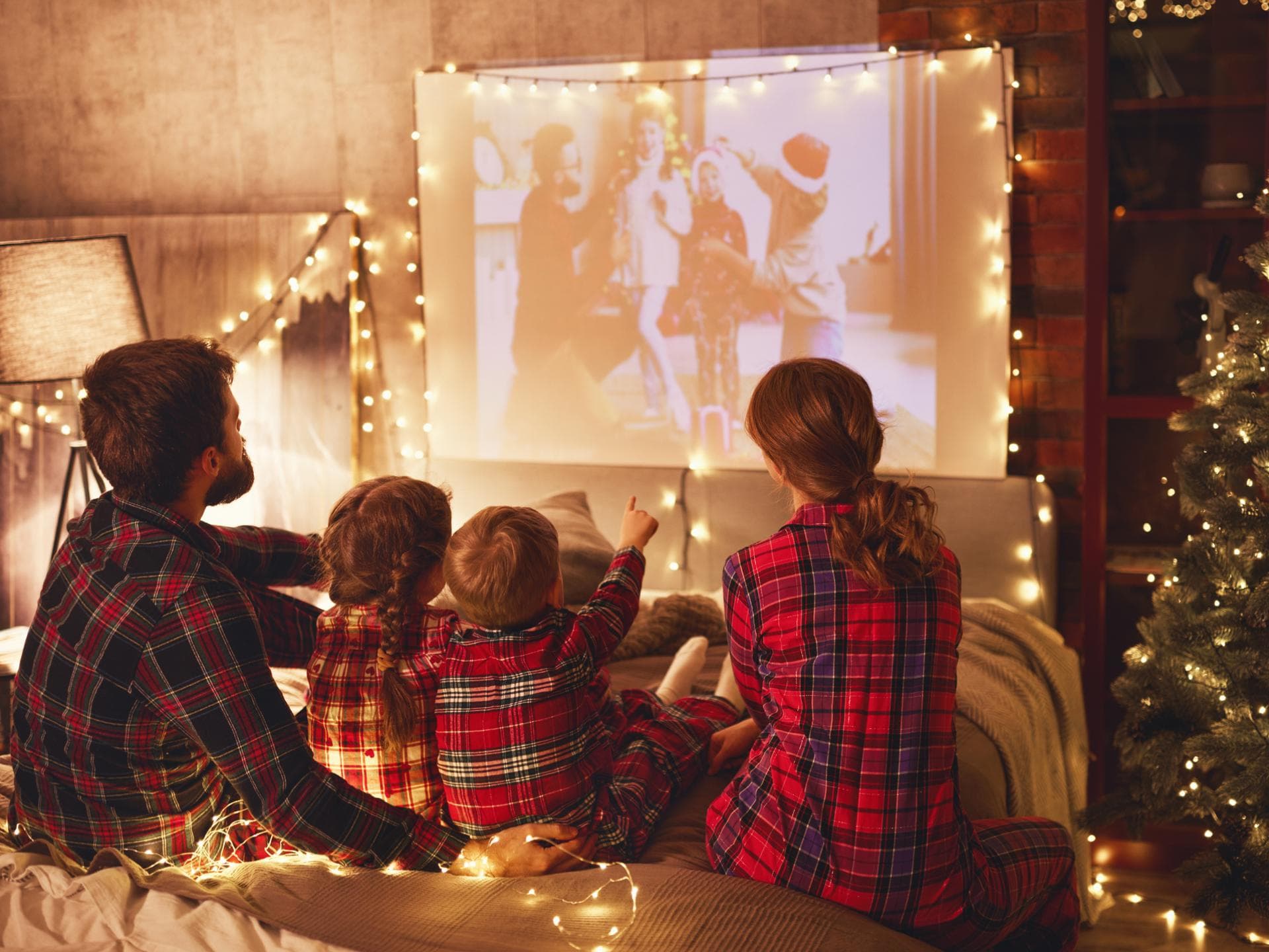 Familie schaut Weihnachtsfilme auf Beamer