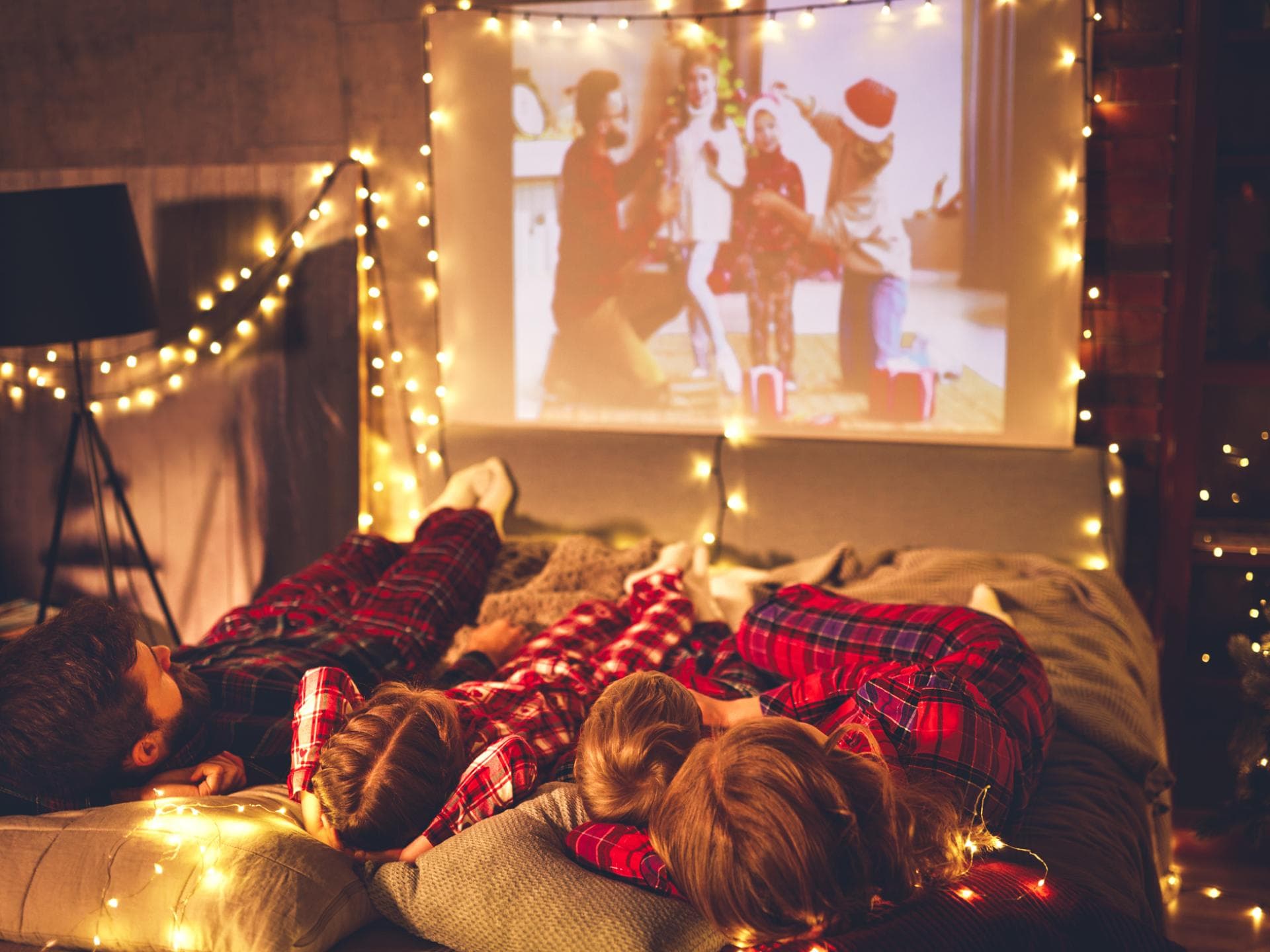 Familie schaut Weihnachtsfilme auf Beamer