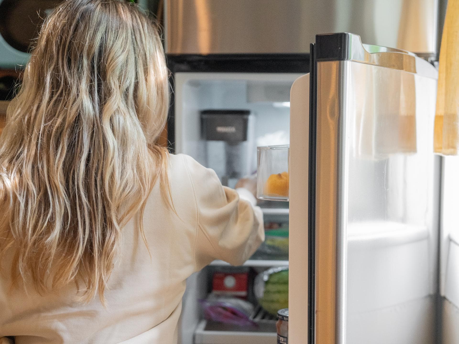 Frau vor dem Kühlschrank