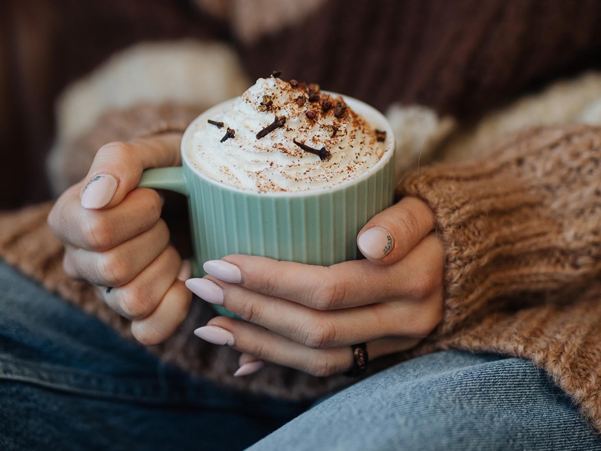 Frau hält Tasse mit Heißgetränk