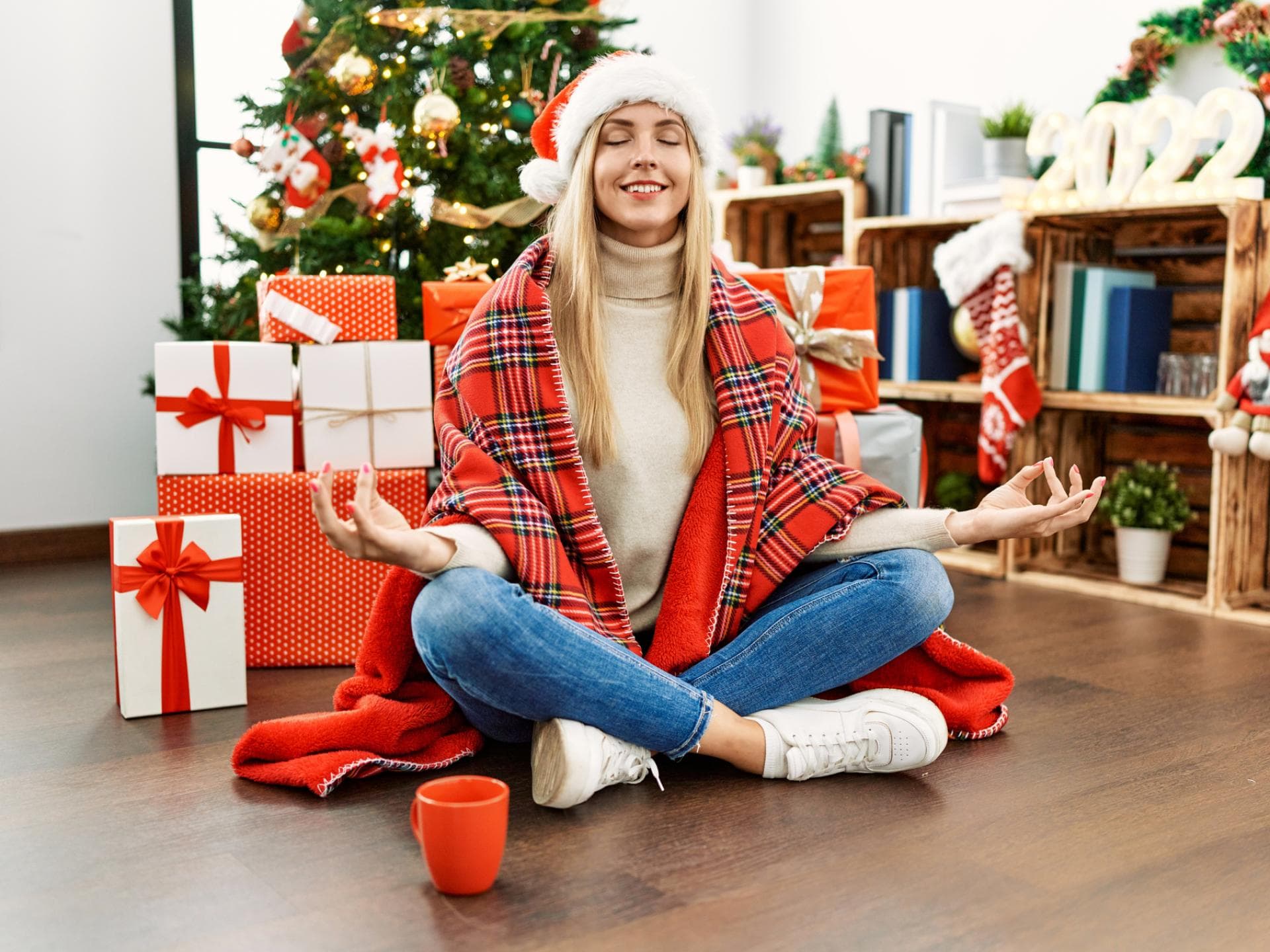 Frau meditiert vor dem Weihnachtsbaum