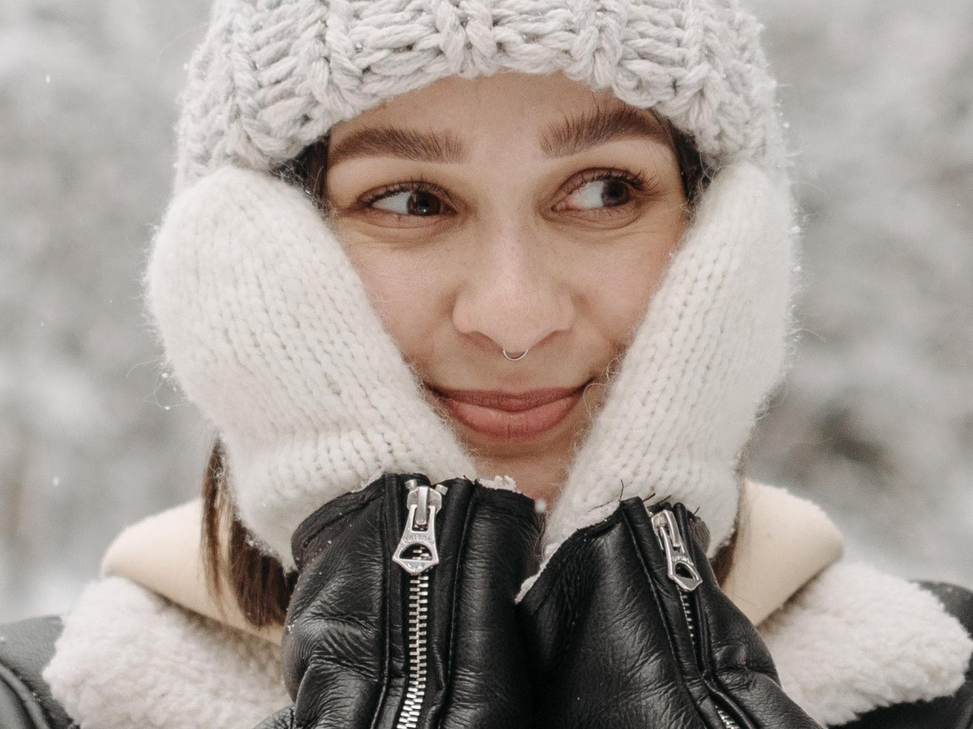 Frau mit Handschuhen steht im Schnee