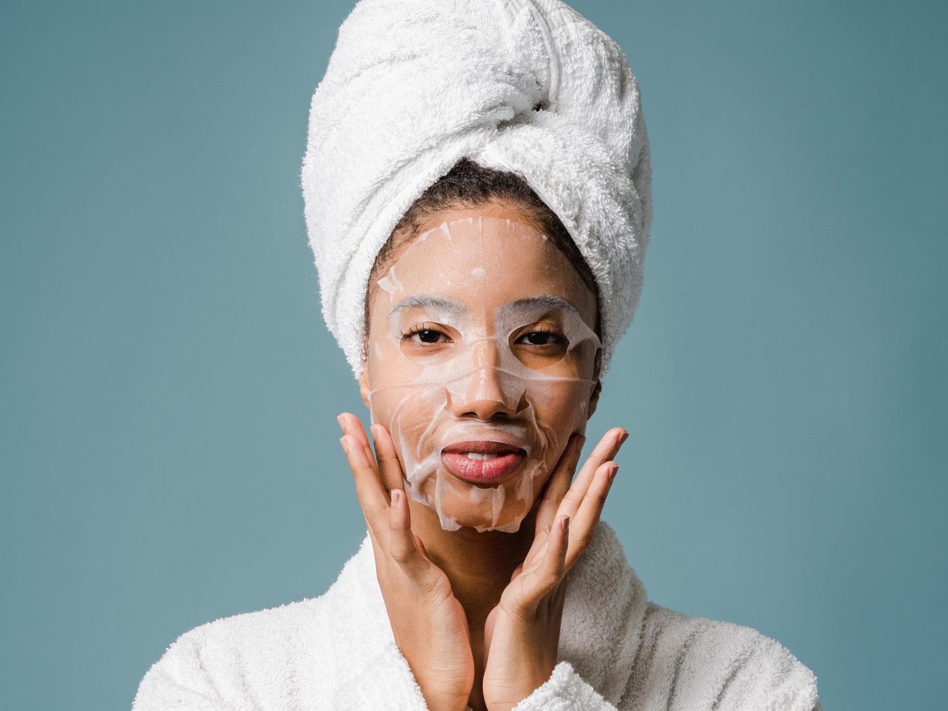 Frau im Bademantel mit Gesichtsmaske