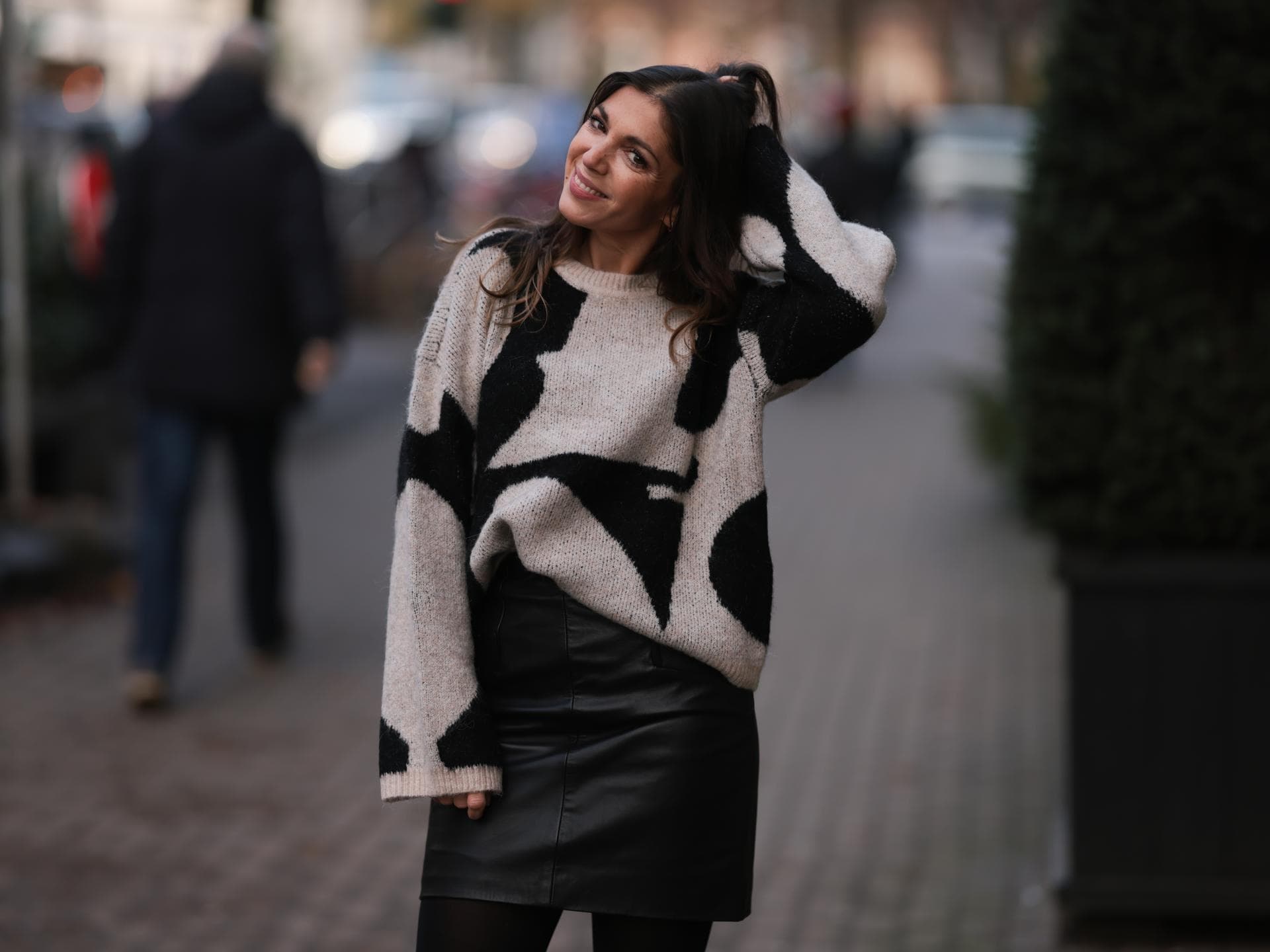 Frau trägt Pullover und Lederrock