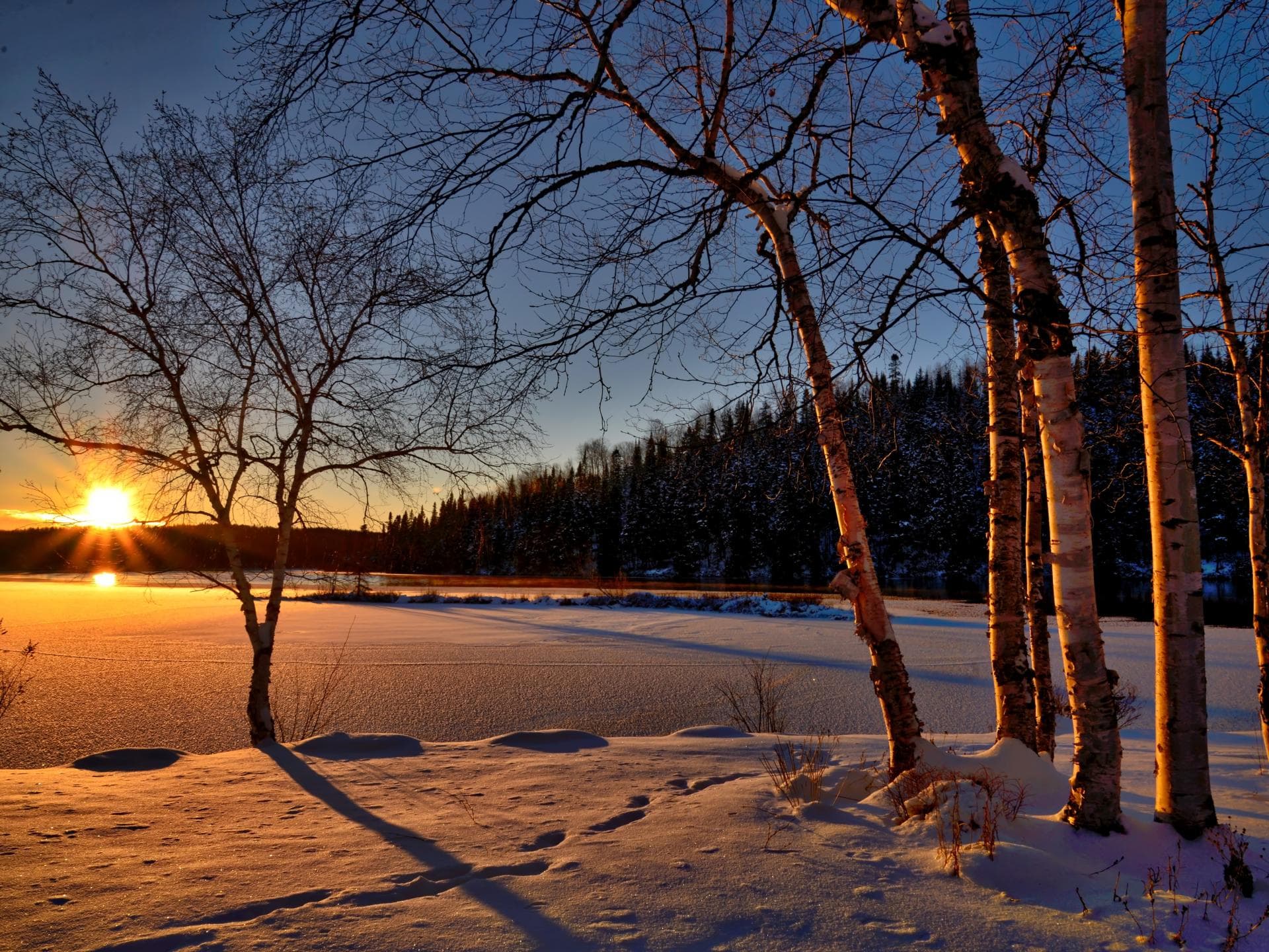 Sonne geht vor Winterlandschaft unter