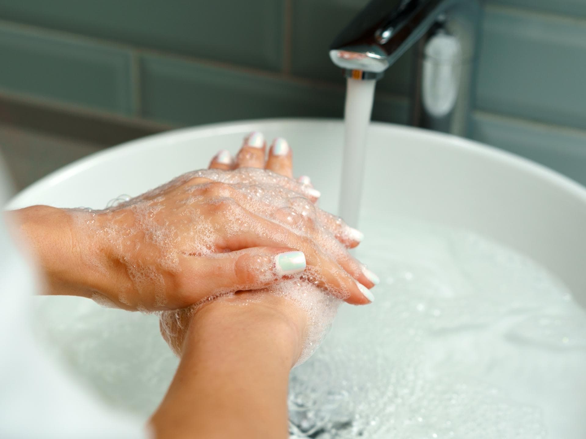 Frau hält Hände unter Wasser