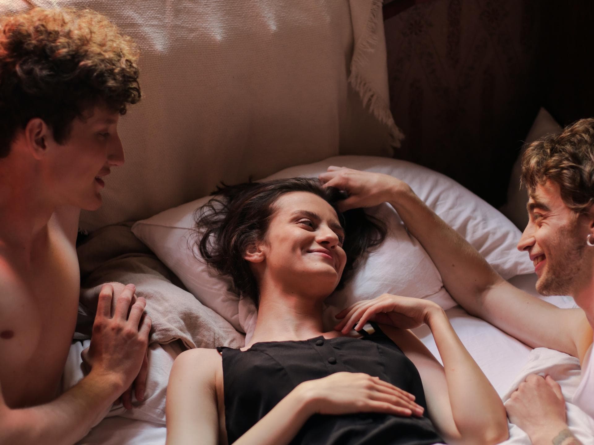 Frau und zwei Männer im Bett