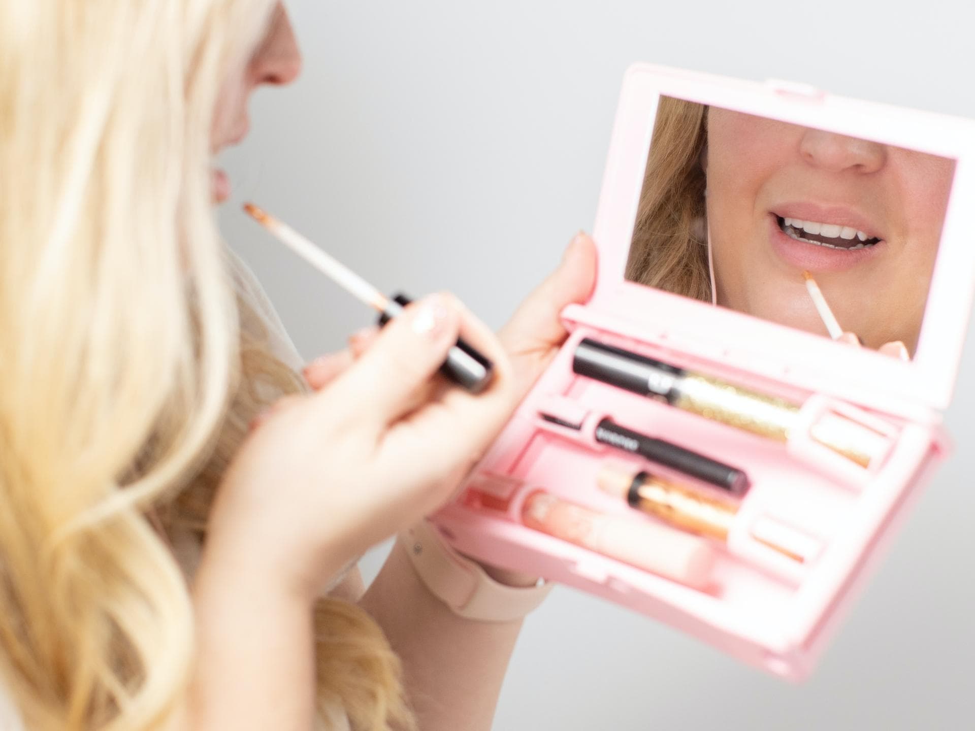 Frau trägt Lipgloss auf