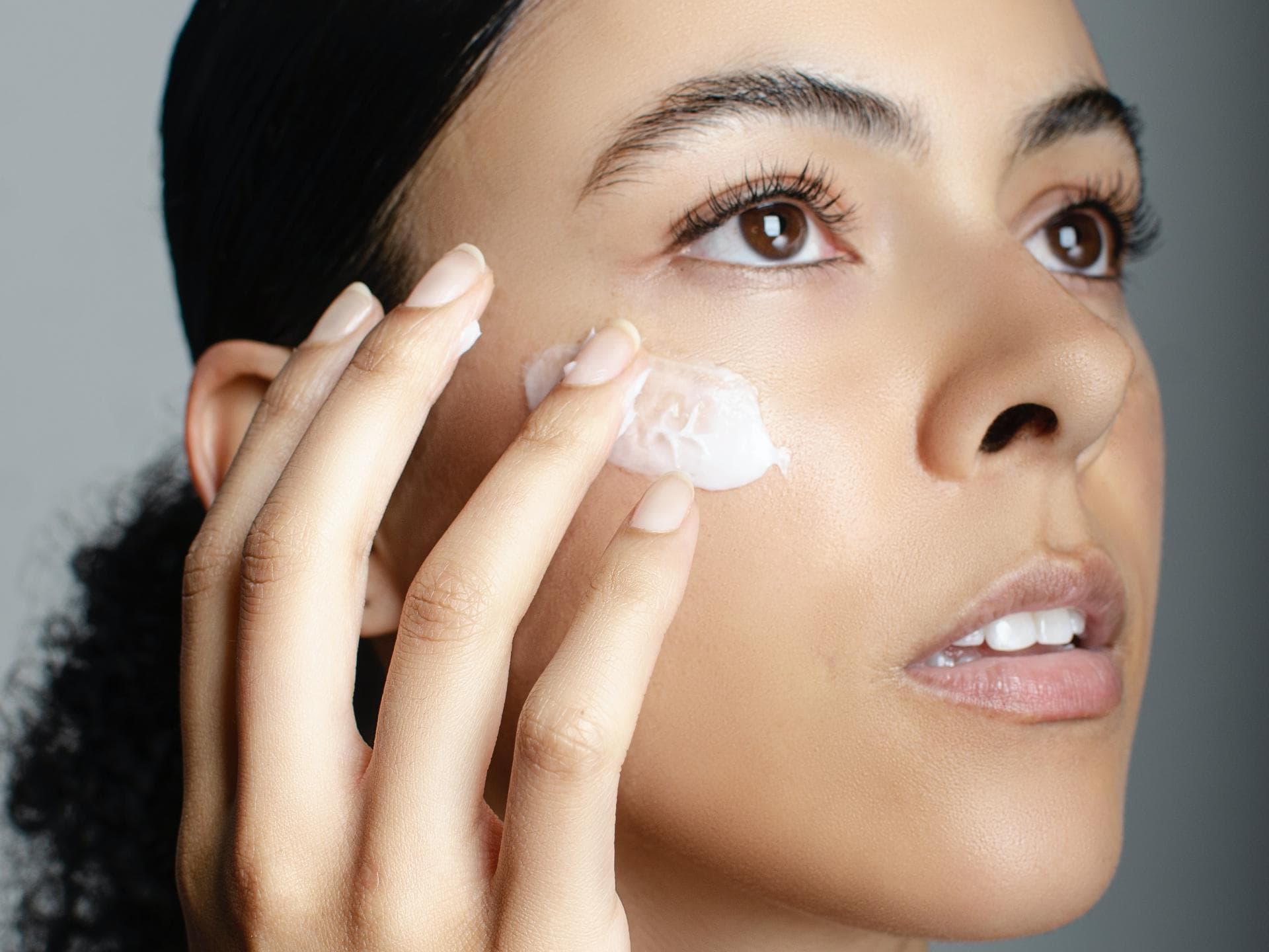 Ceramide Creme Frau trägt Gesichtscreme auf