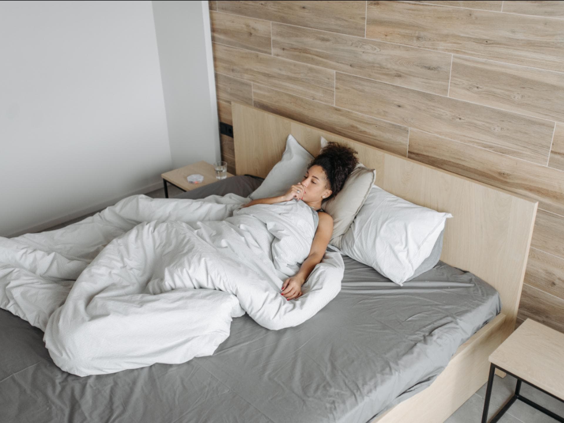 Frau im Bett mit Husten