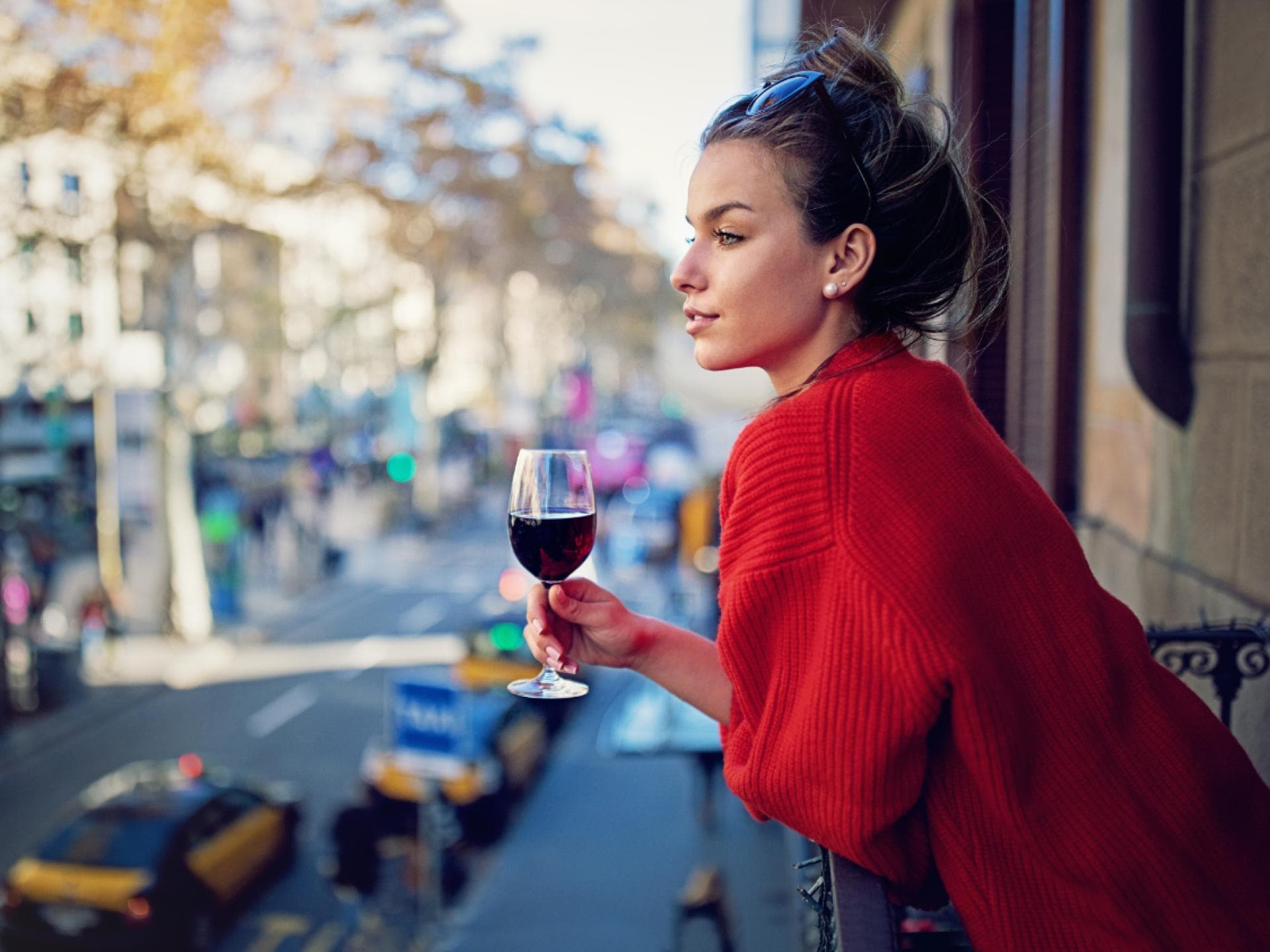 Frau mit Wein auf Balkon