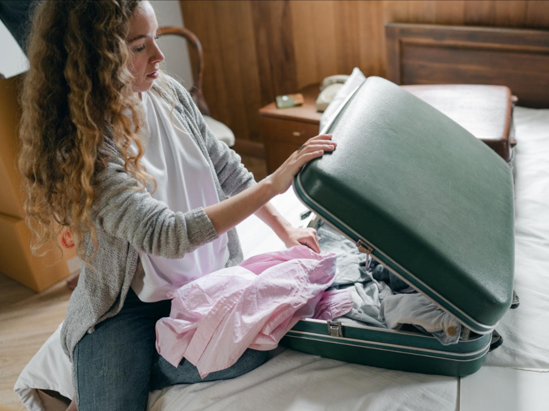 Frau packt ihren Koffer auf dem Bett