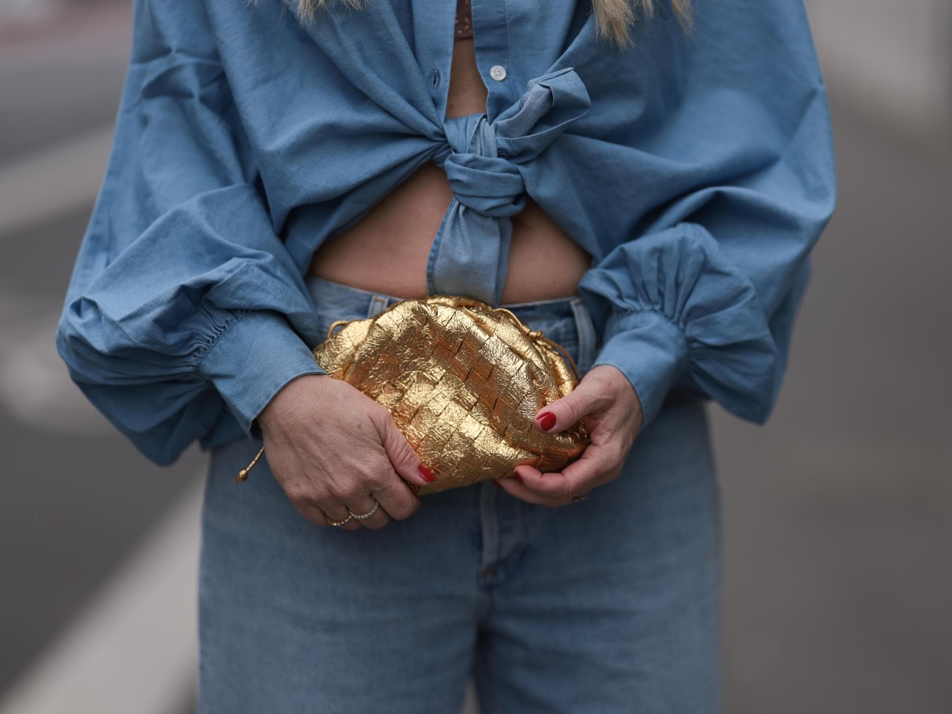 Frau trägt goldene Tasche
