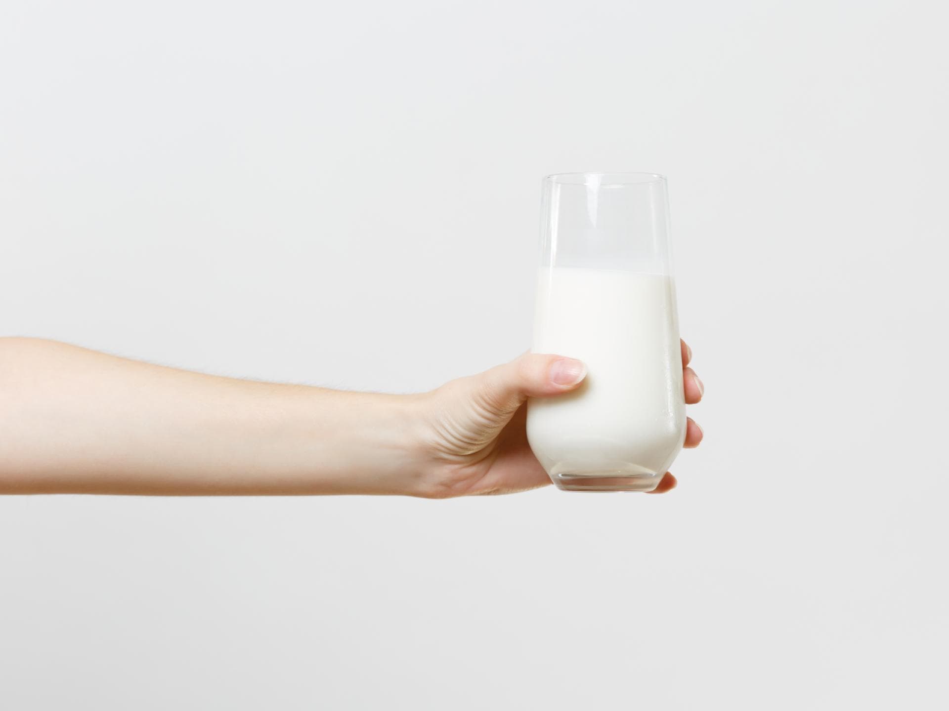 Frau hält Milch in der Hand