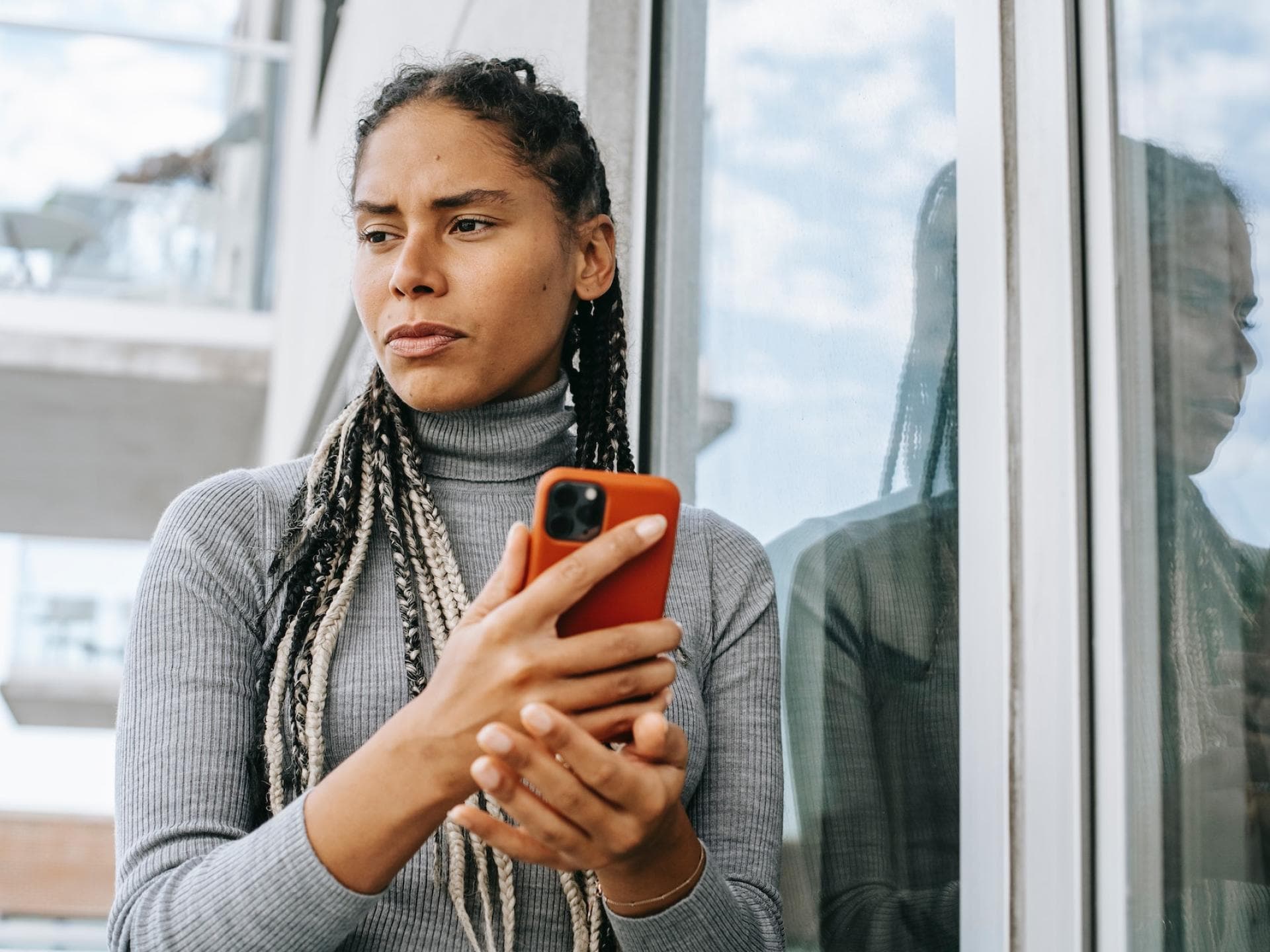 Frau hält ein Handy in der Hand und guckt traurig