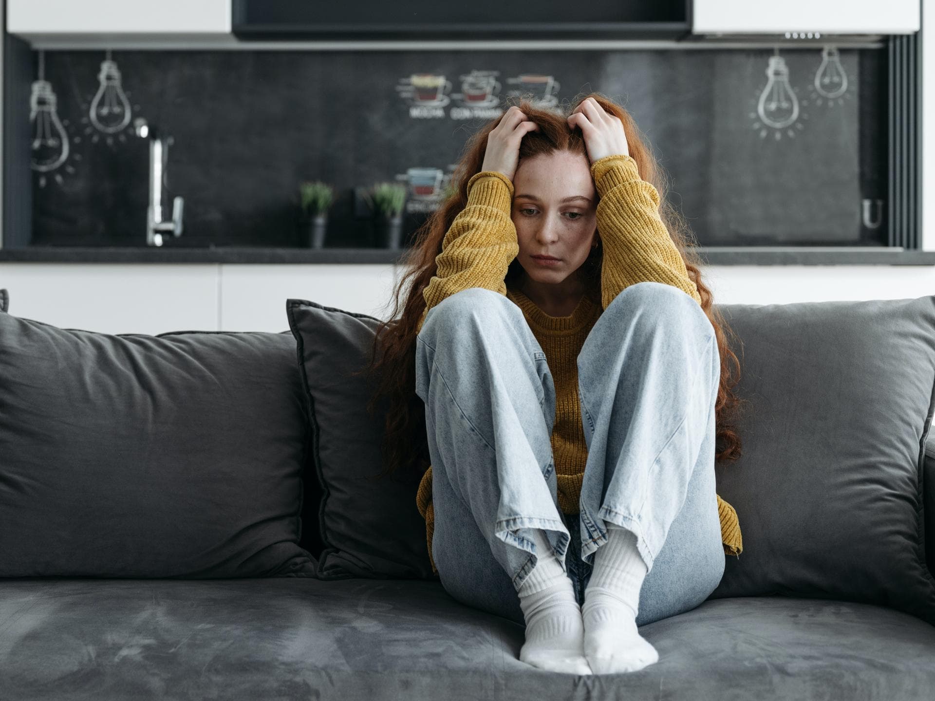 Frau sitzt gestresst auf dem Sofa