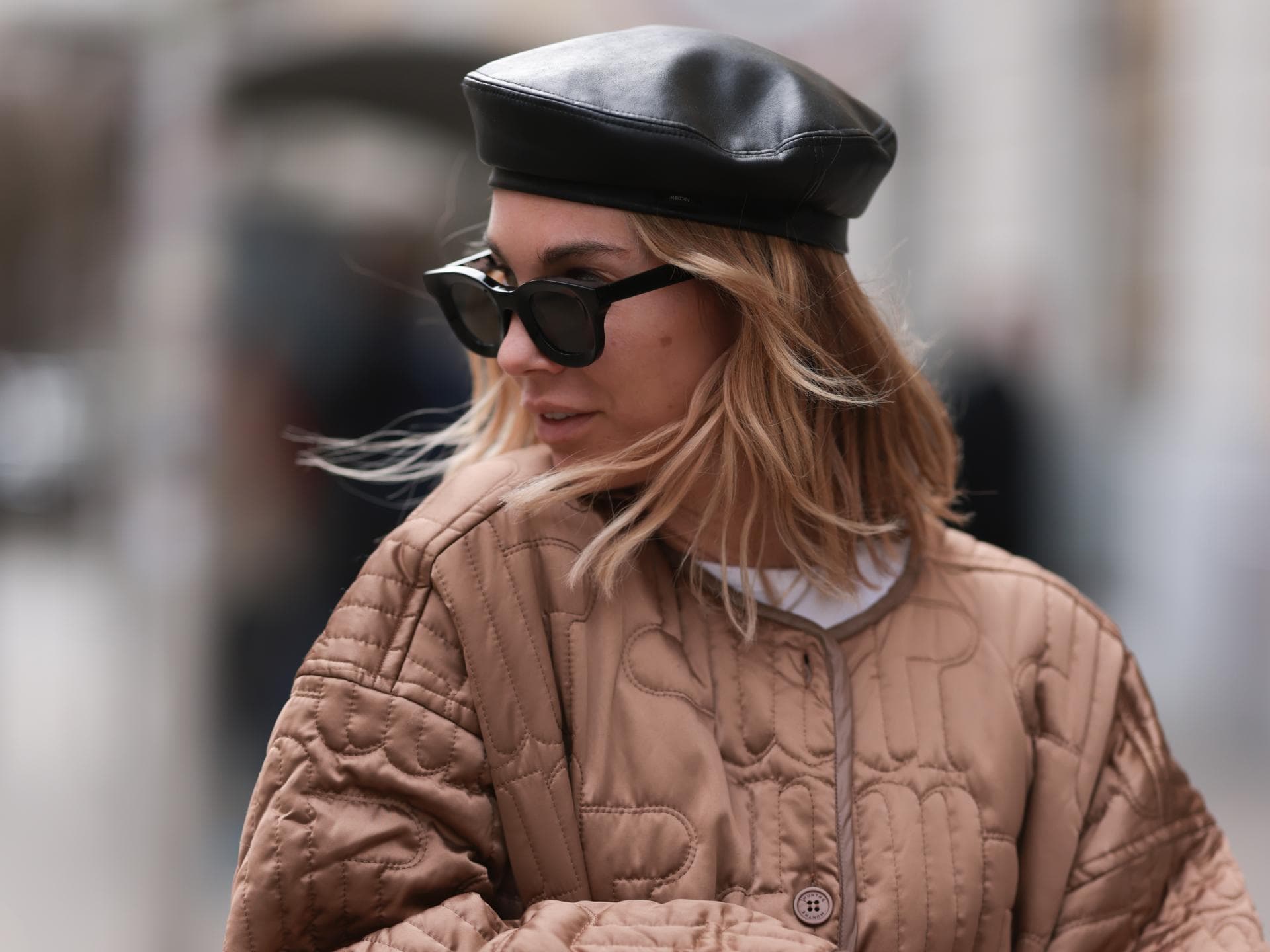 3 Herbst-Trends unter 40 Euro, die wir uns schon im August sichern Frau trägt Baskenmütze, Steppjacke und Kelly Bag