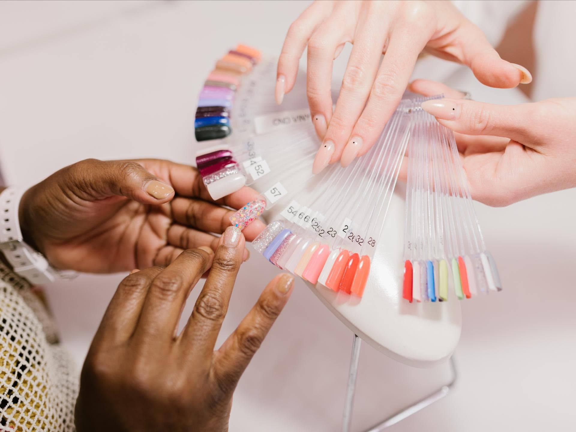 Frau wählt Nagellackfarben aus Frau wählt Nagellackfarben aus
