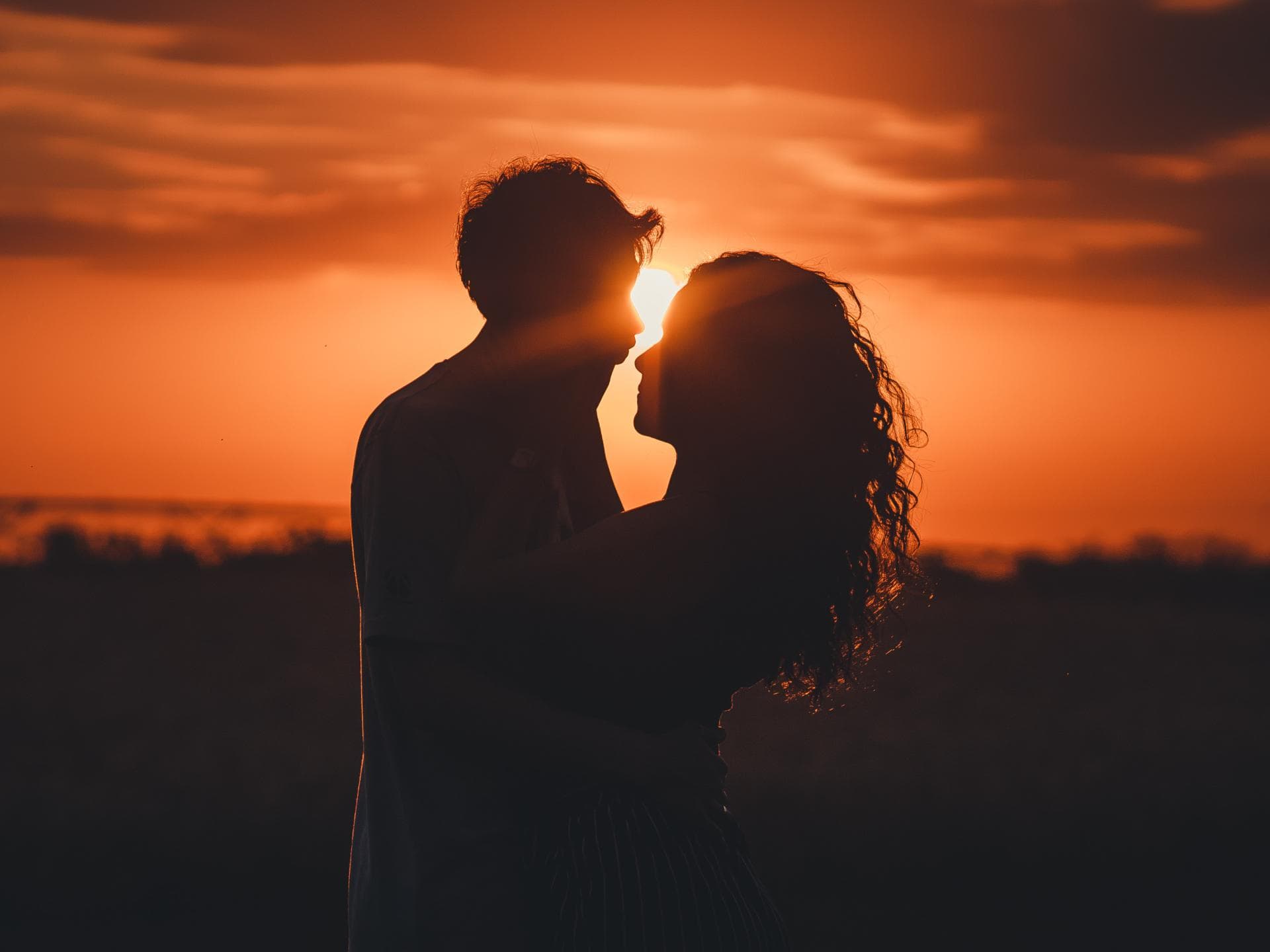 Große Liebe Sternzeichen Mann und Frau umarmen sich mit Sonnenuntergang im Hintergrund
