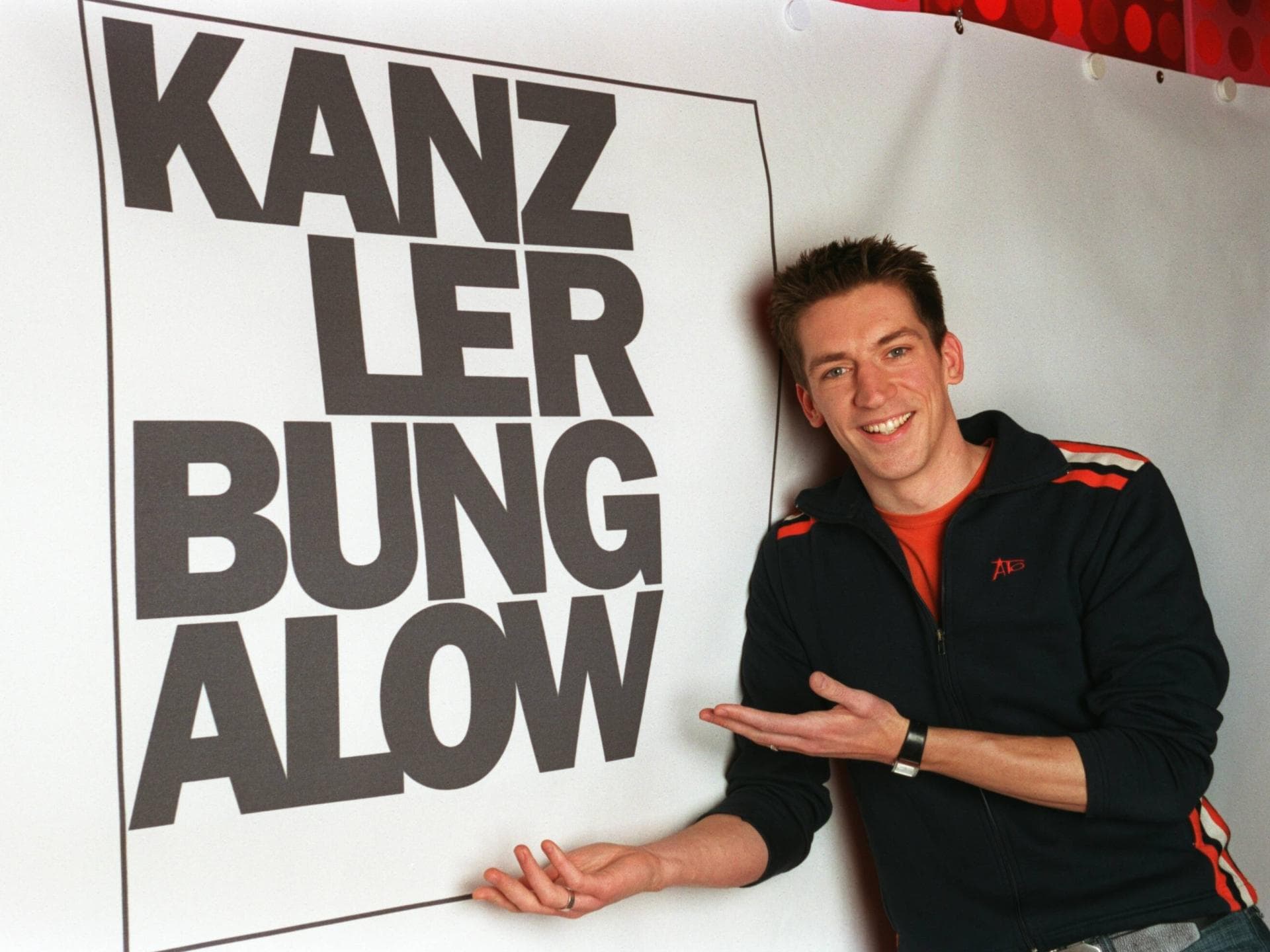 Steffen Hallaschka vor einem Plakat der WDR-Politikshow "Kanzlerbungalow"