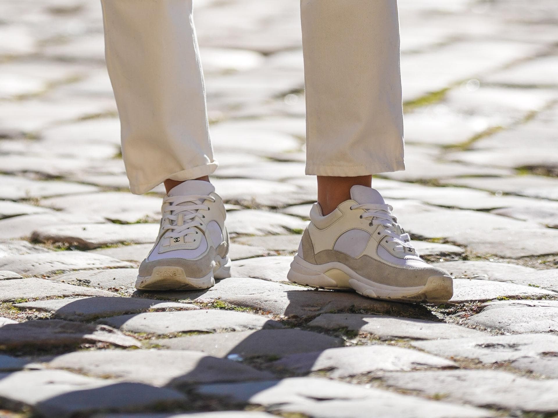 Kein anderer Sneaker zaubert dir längere Beine als dieser Trend-Schuh von H&M Frau trägt beige-weiße Sneaker mit Plateau-Sohle