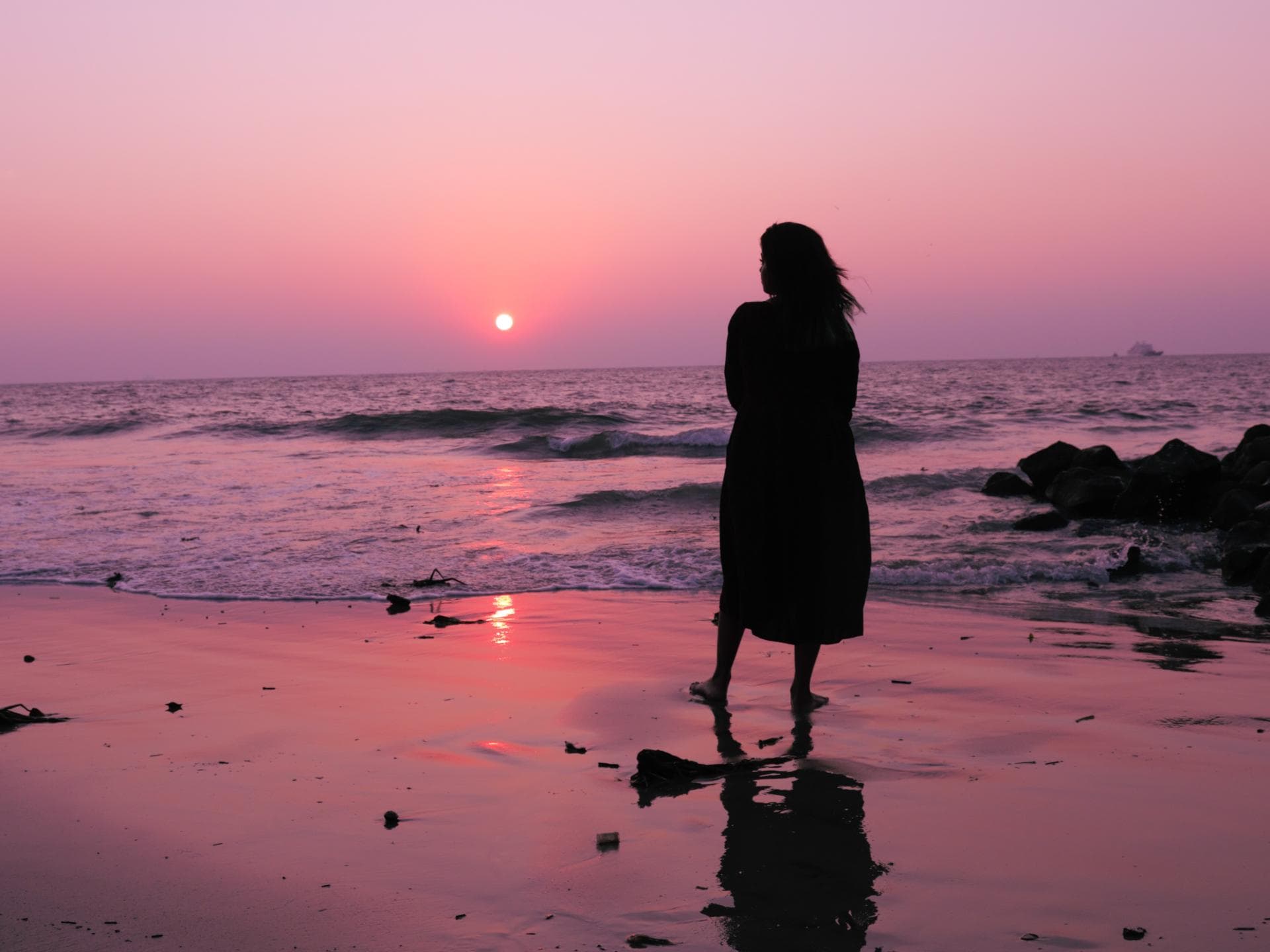 Pech-Sternzeichen am Wochenende Frau steht am Strand und schaut den Himmel an