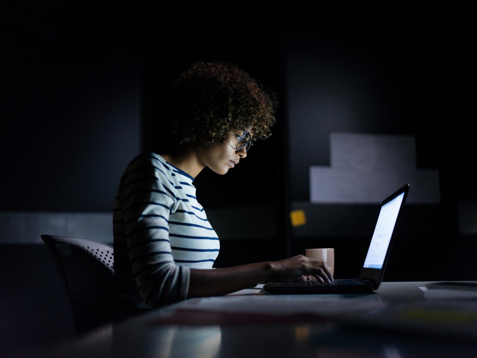 Fear of Being Offline Junge Frau sitzt nachts am Laptop