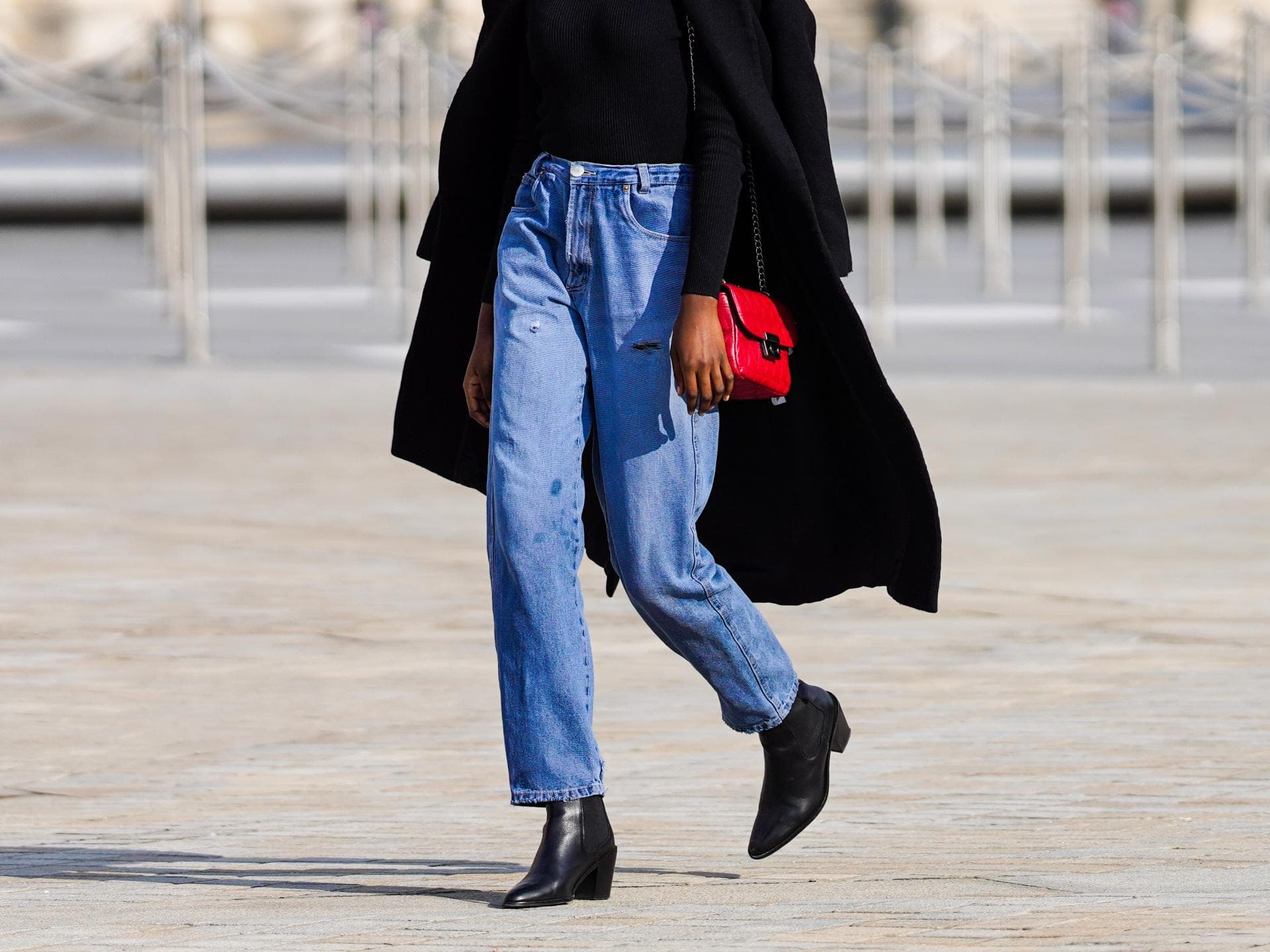Frau trägt rote Tasche und Jeans