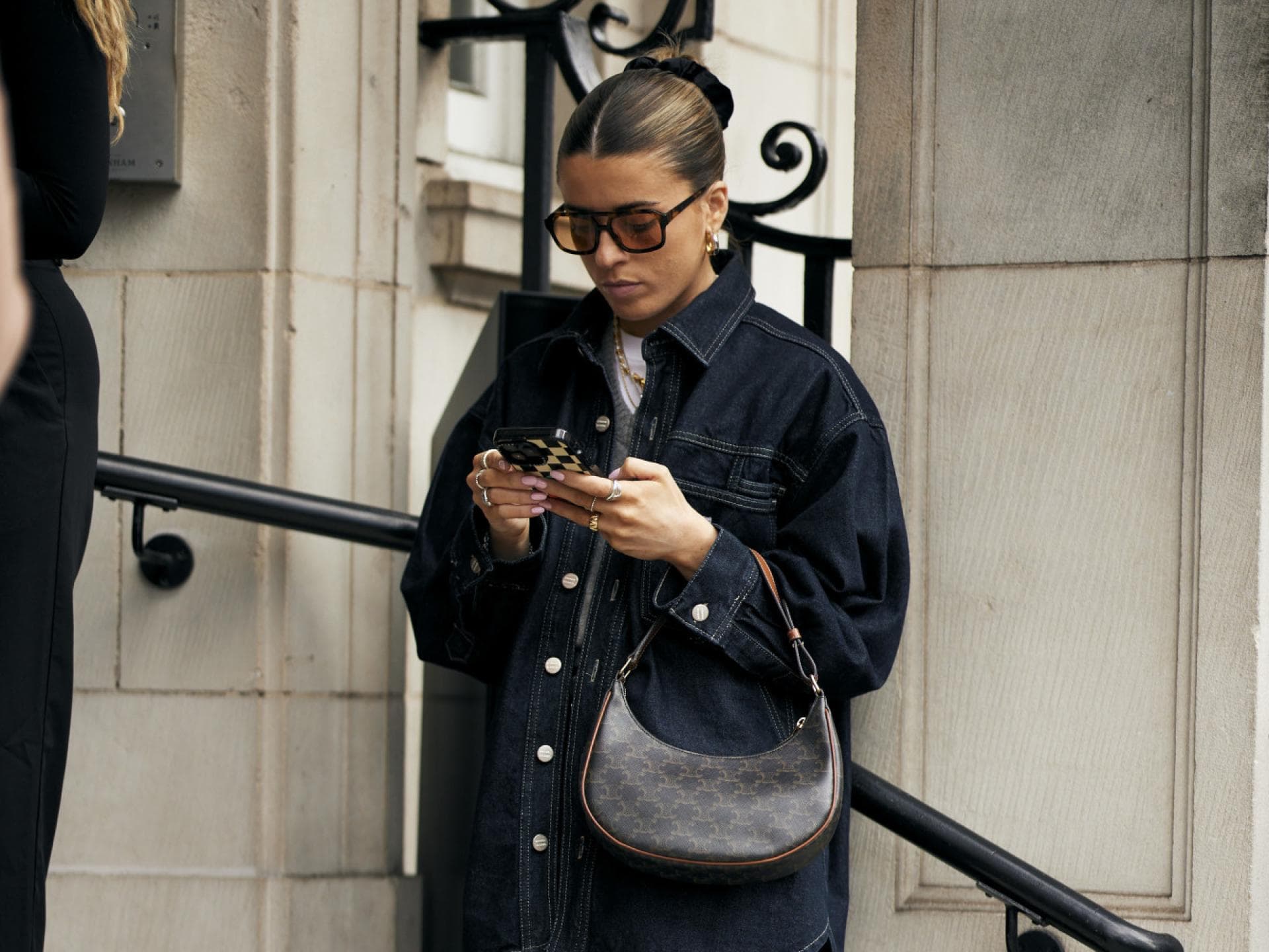 3 Micro-Trends, die gerade unaufhaltbar sind Frau mit Retro-Sonnenbrille schaut auf ihr Handy
