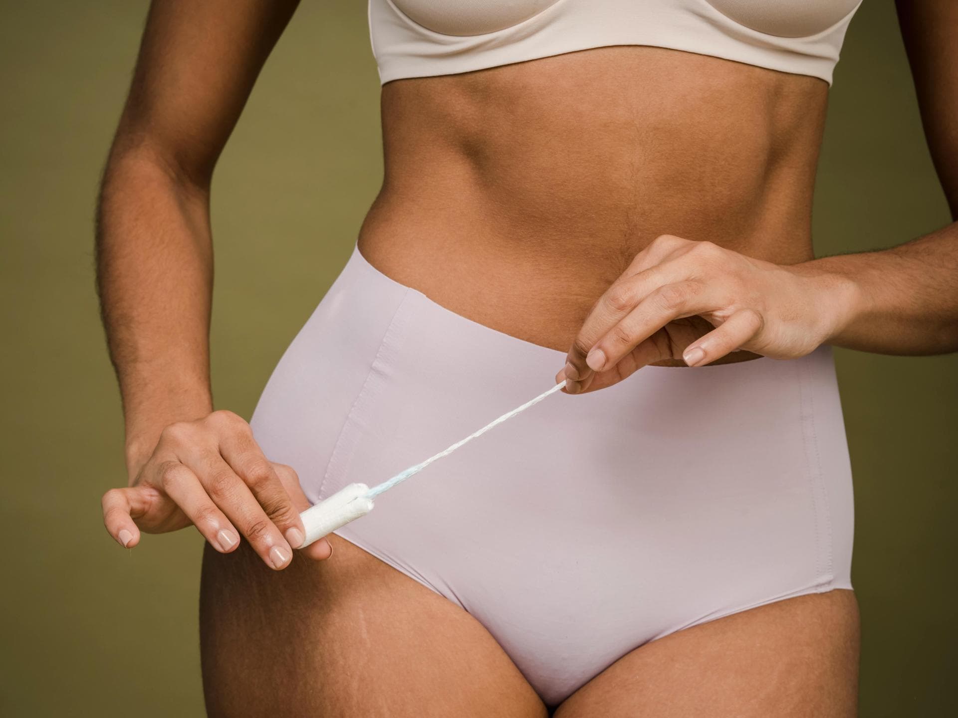 Frau mit Periodenunterwäsche und Tampon in der Hand
