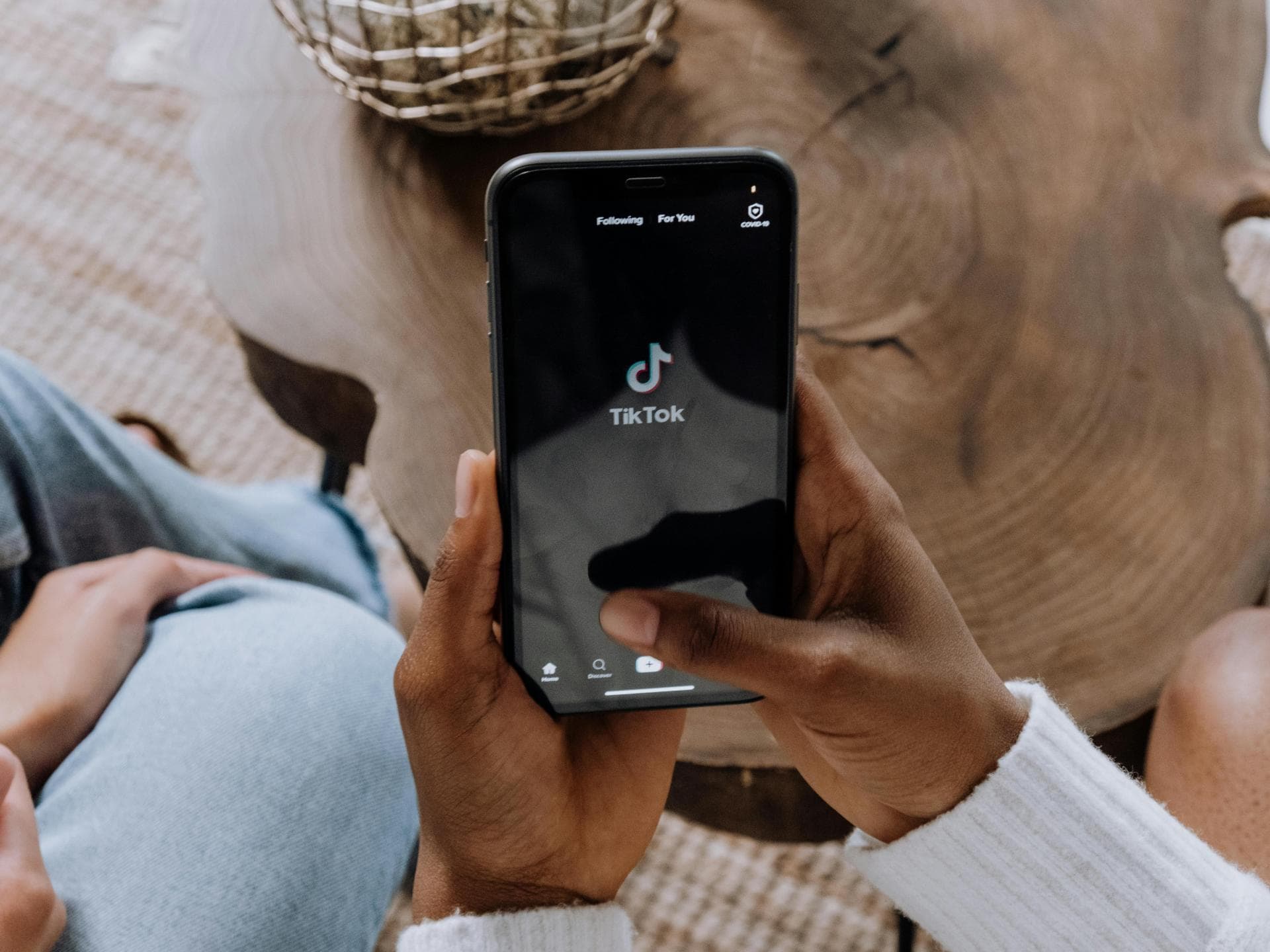 Frau hält Handy mit der TikTok App