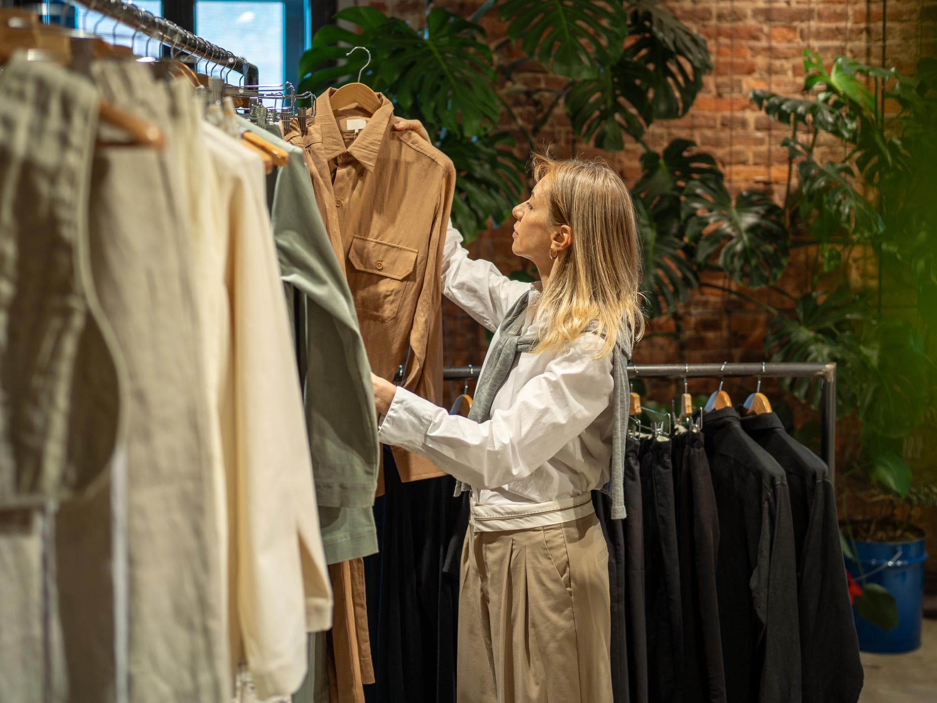Diese Alternative zu Fast Fashion beschert dir einen unendlichen Kleiderschrank Frau schaut sich Kleidung an