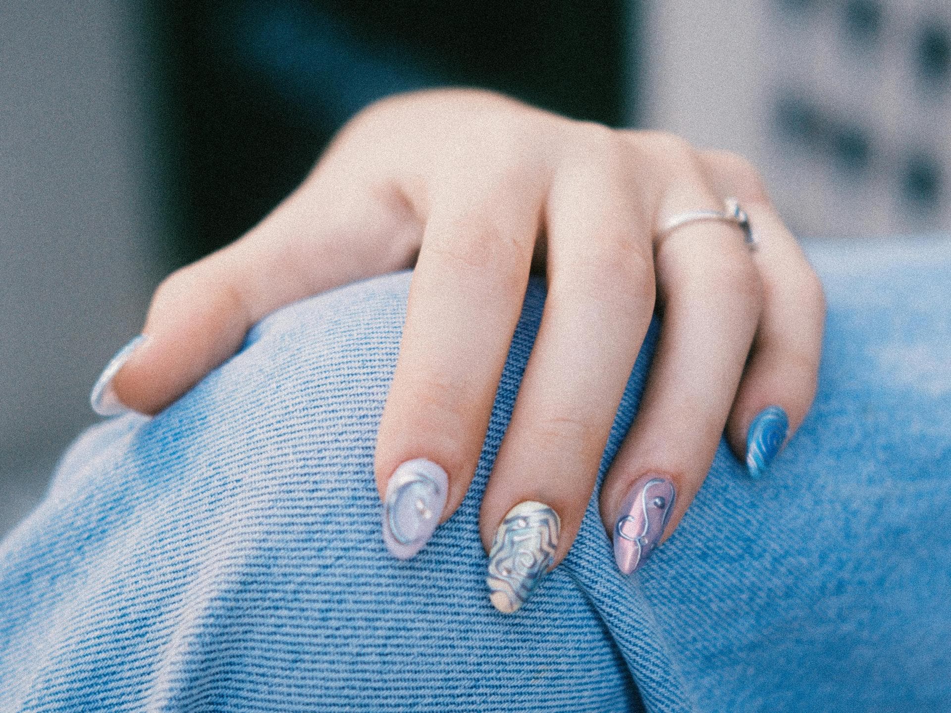 K-Pop Nails Eine Hand mit einer kreativen blauen Maniküre