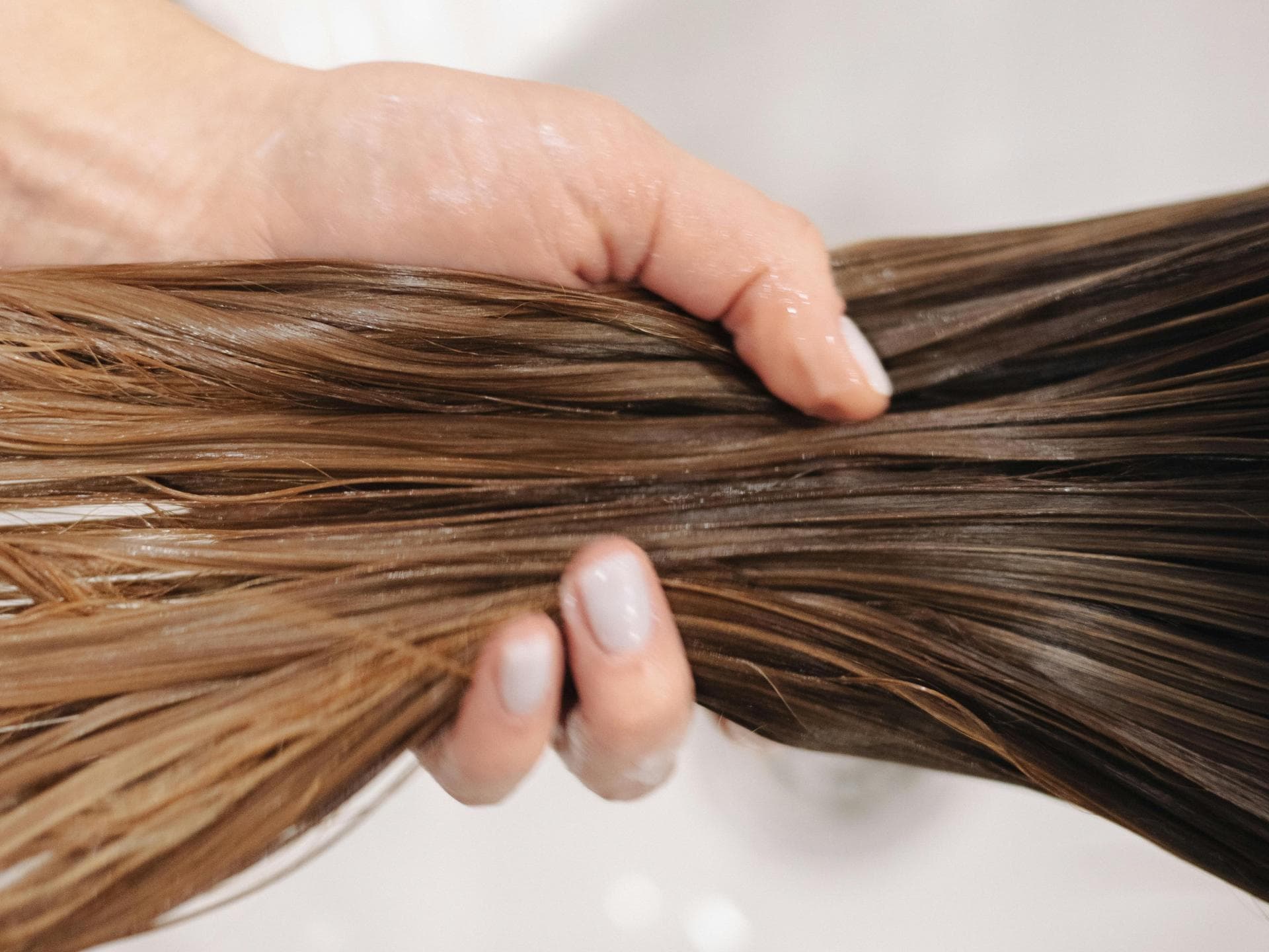 Pre-Shampoo-Behandlungen Frau haelt Haare