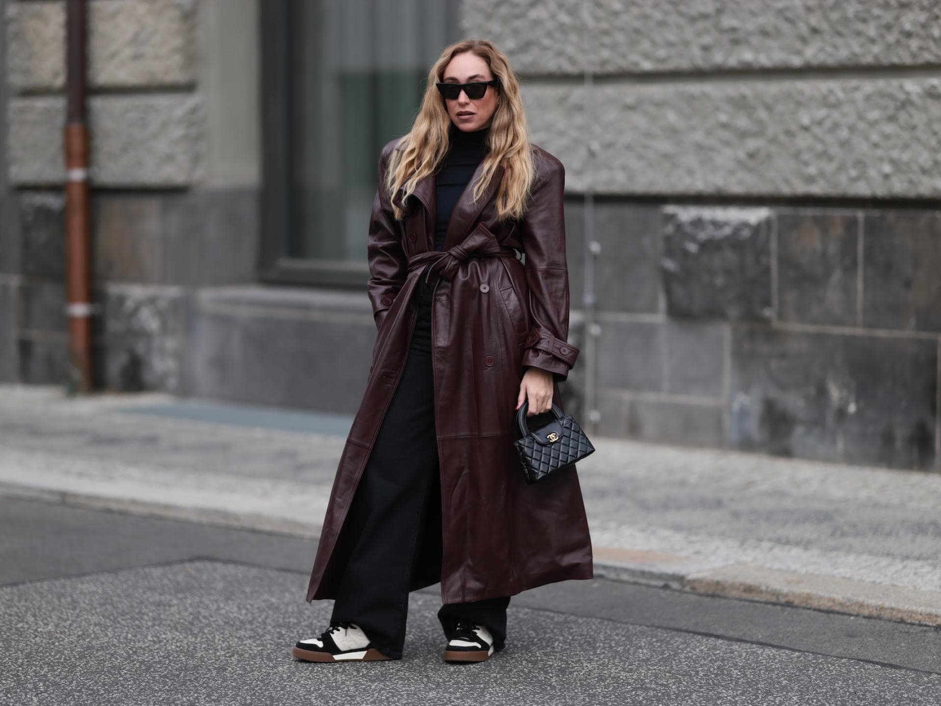 Braun und Schwarz sind im Herbst eine tolle Kombi. Frau mit blonden Haaren und einem braunen Ledermantel.