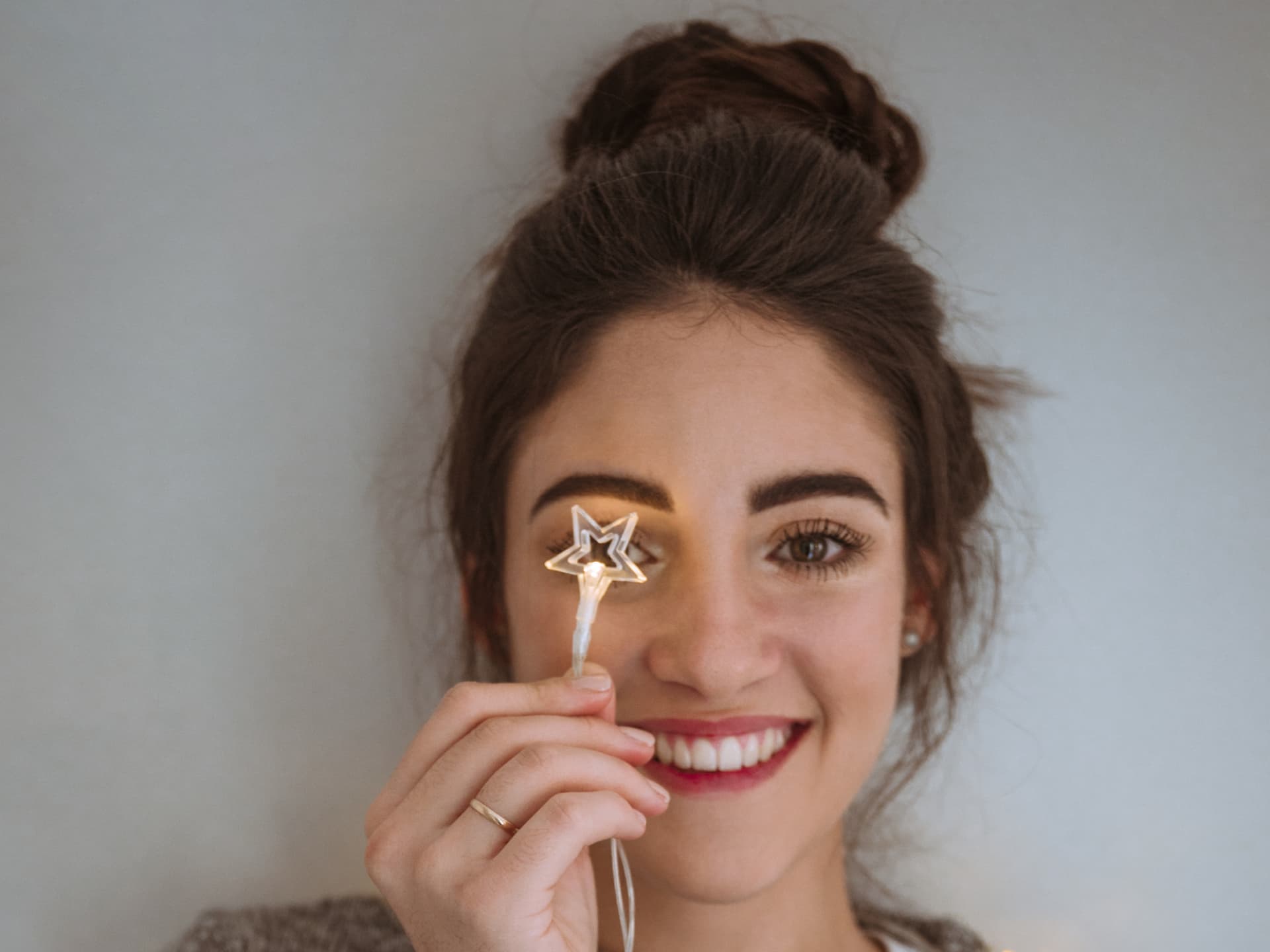 Mädchen in Weihnachtspulli mit Sternen-Lichterkette Mädchen in Weihnachtspulli mit Sternen-Lichterkette