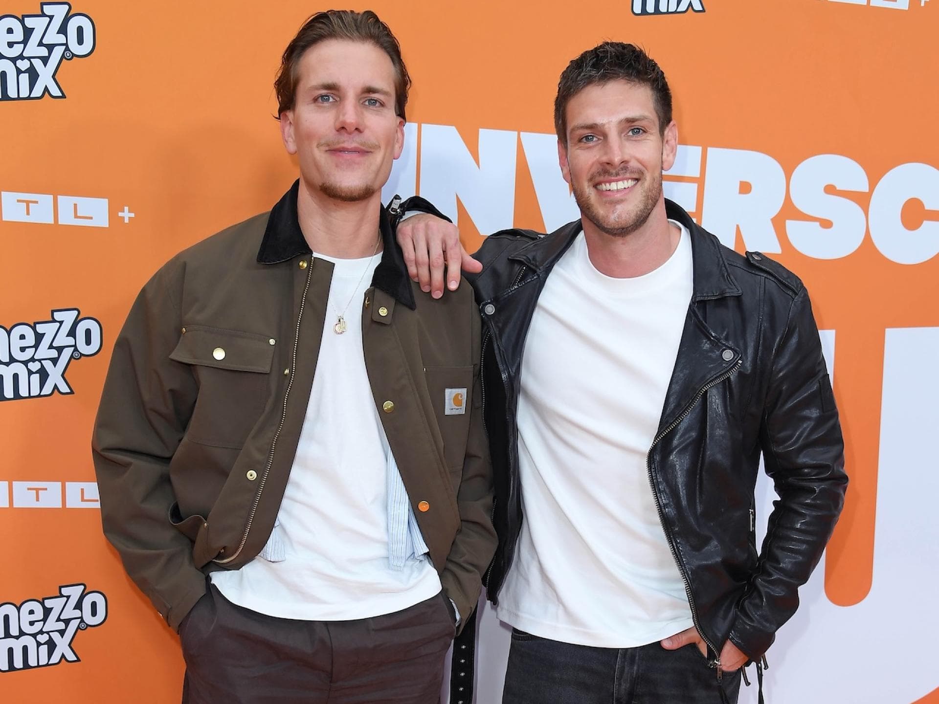 Felix Stein und Martin Braun vor einer orangefarbenen Wand.