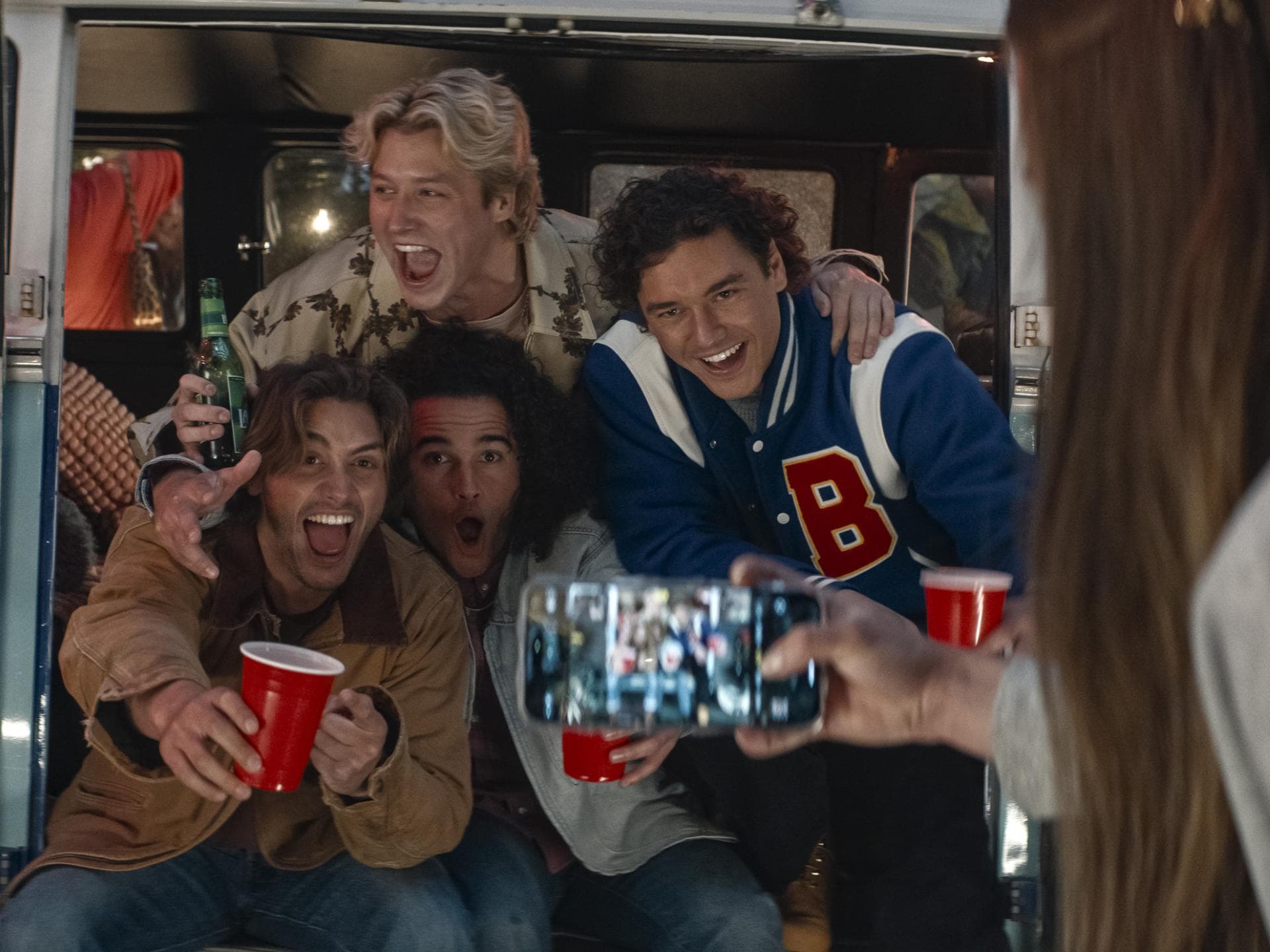 In „Off Campus“ geht es um Eishockey, Partys und Beziehungen. Ein paar Jugendliche feiern auf einer Party mit Getränken und werden fotografiert.
