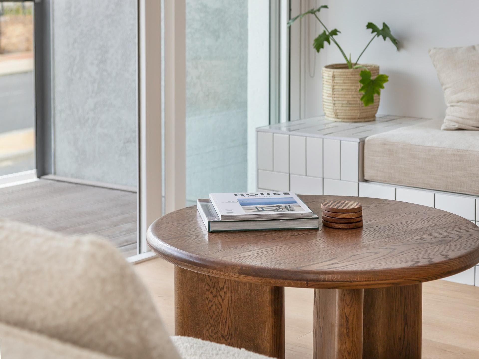 Die richtigen Farben und Accessoires verleihen deiner Wohnung sofort ein Upgrade. Ein Wohnzimmerausschnitt mit einem Couchtisch und einer Tür nach draußen.