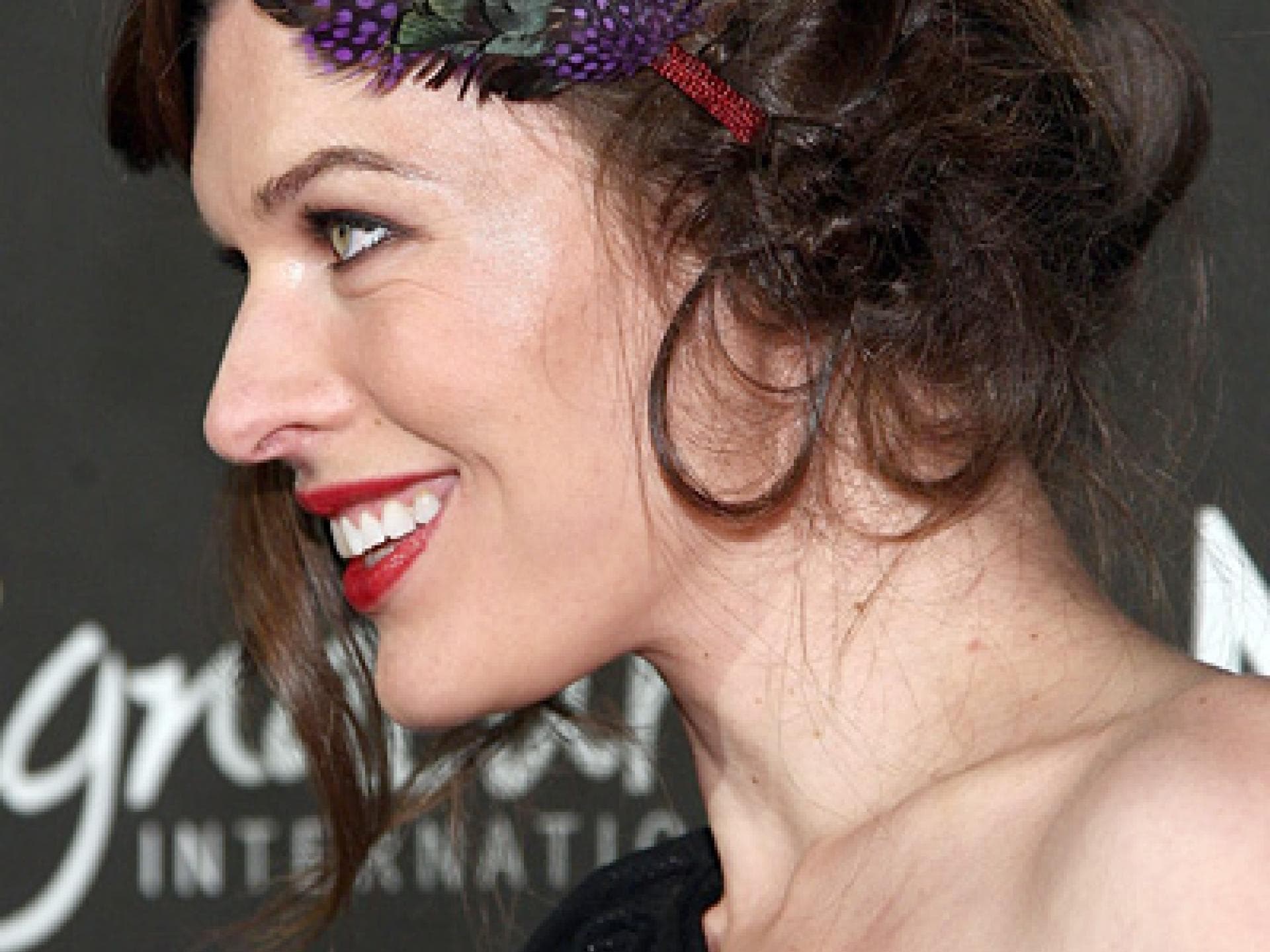 Milla Jovovich mit Federschmuck im Haar